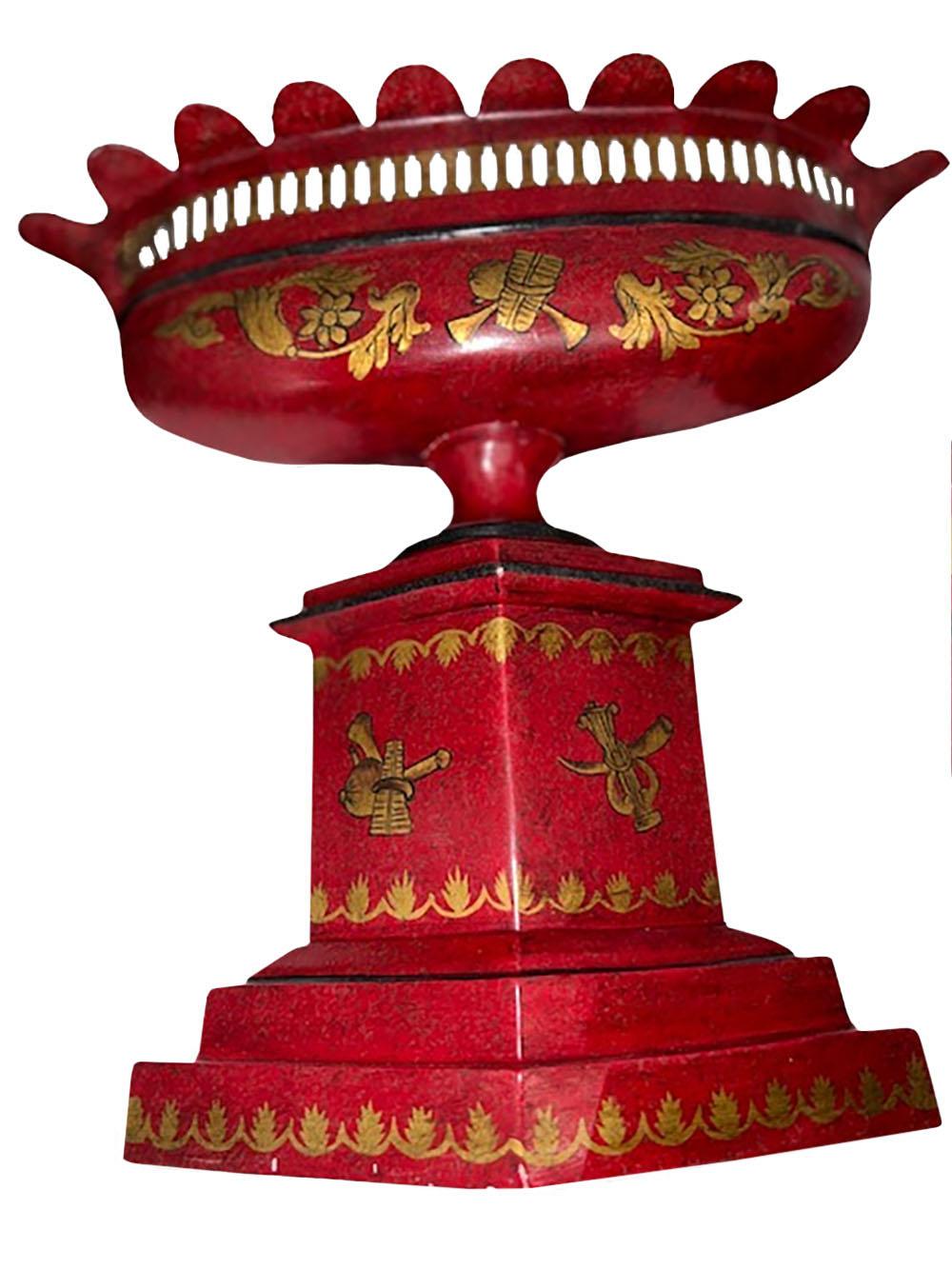 Une paire de jardinières de forme ovale en tole rouge, avec un décor doré d'urnes, de guirlandes et de fleurs. France 20ème siècle.
