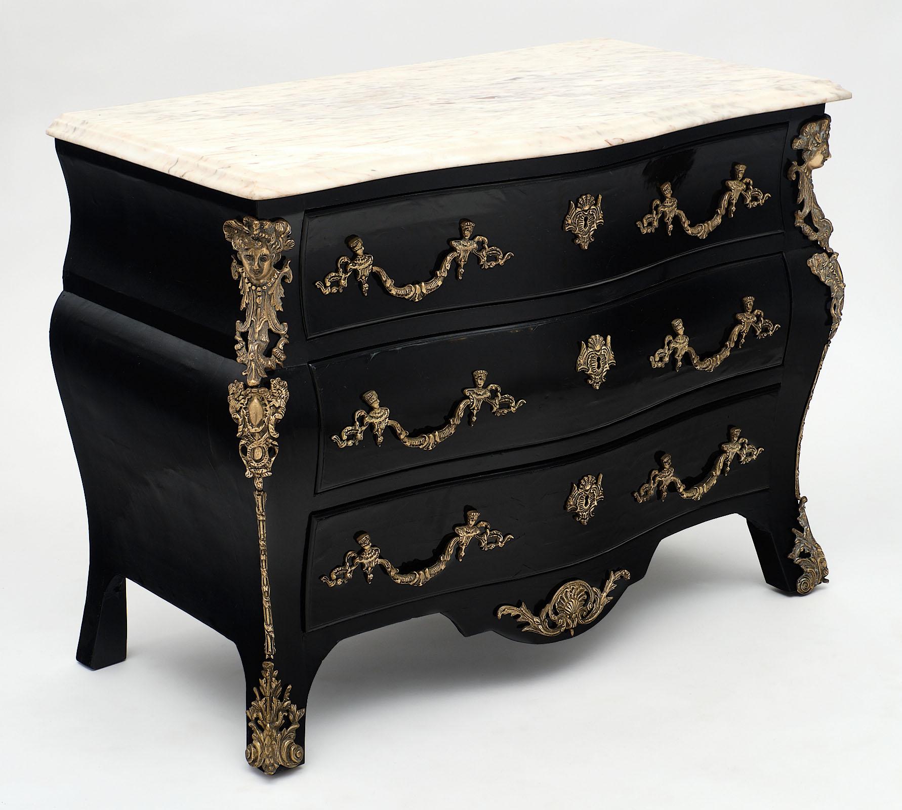 French antique Régence chest of drawers. This beautiful “commode serpentine” has striking; rich ornamentation of finely case gilded bronzes throughout. It has been ebonized and finished with a French polish finish. There are three dovetailed drawers