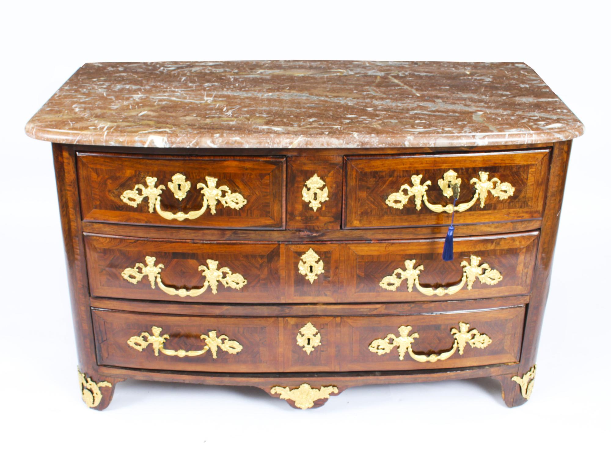 This is an impressive and rare antique French Régence wood and ormolu conmmode, circa 1730 in date.

The stunning breche violette marble top over a serpentine front having two short over two full width drawers, the drawers fitted with scrolling