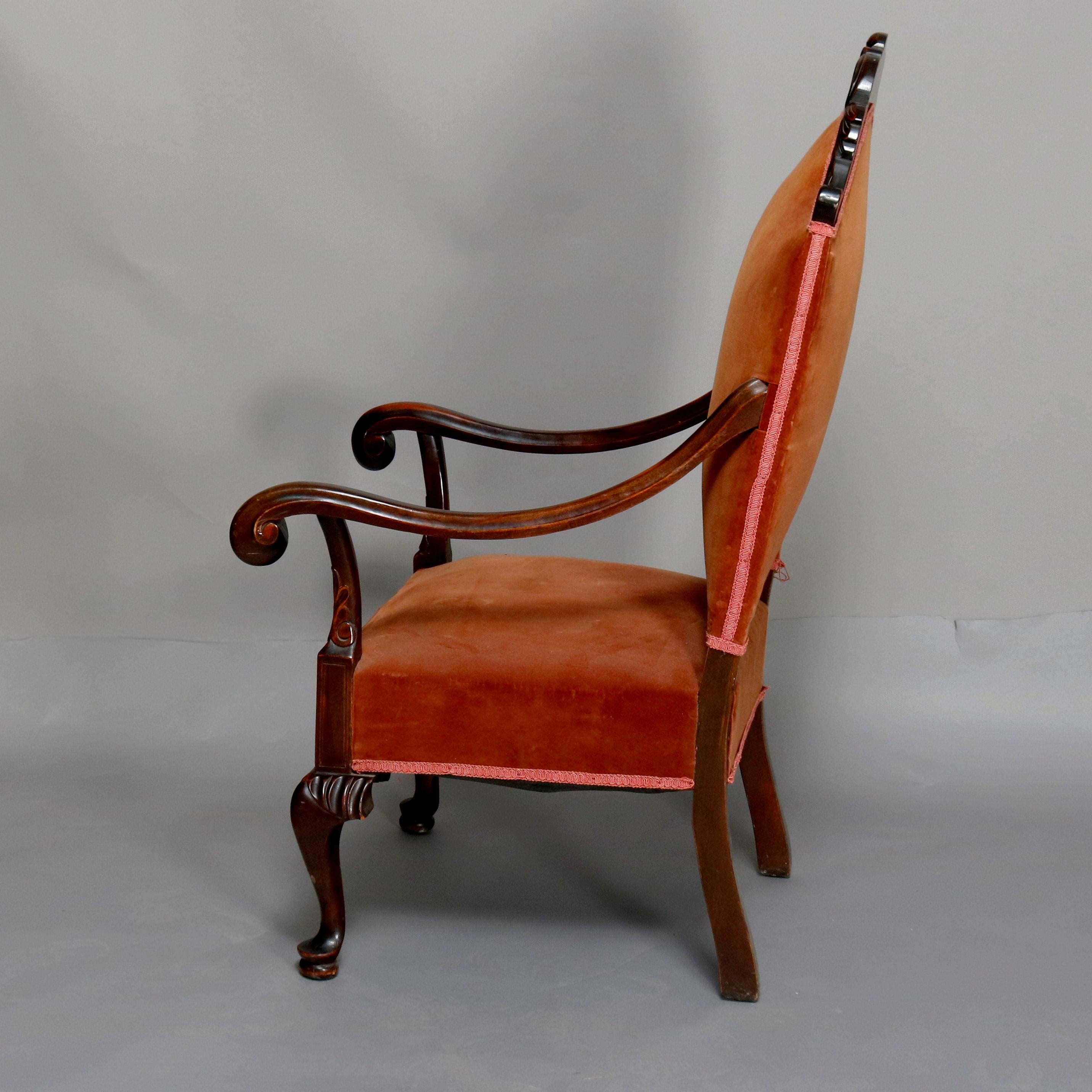 An antique French Regence style throne chair offers mahogany frame with carved acanthus crest, scroll form arms, and cabriole legs with pad feet, 19th century

Measures: 50.5
