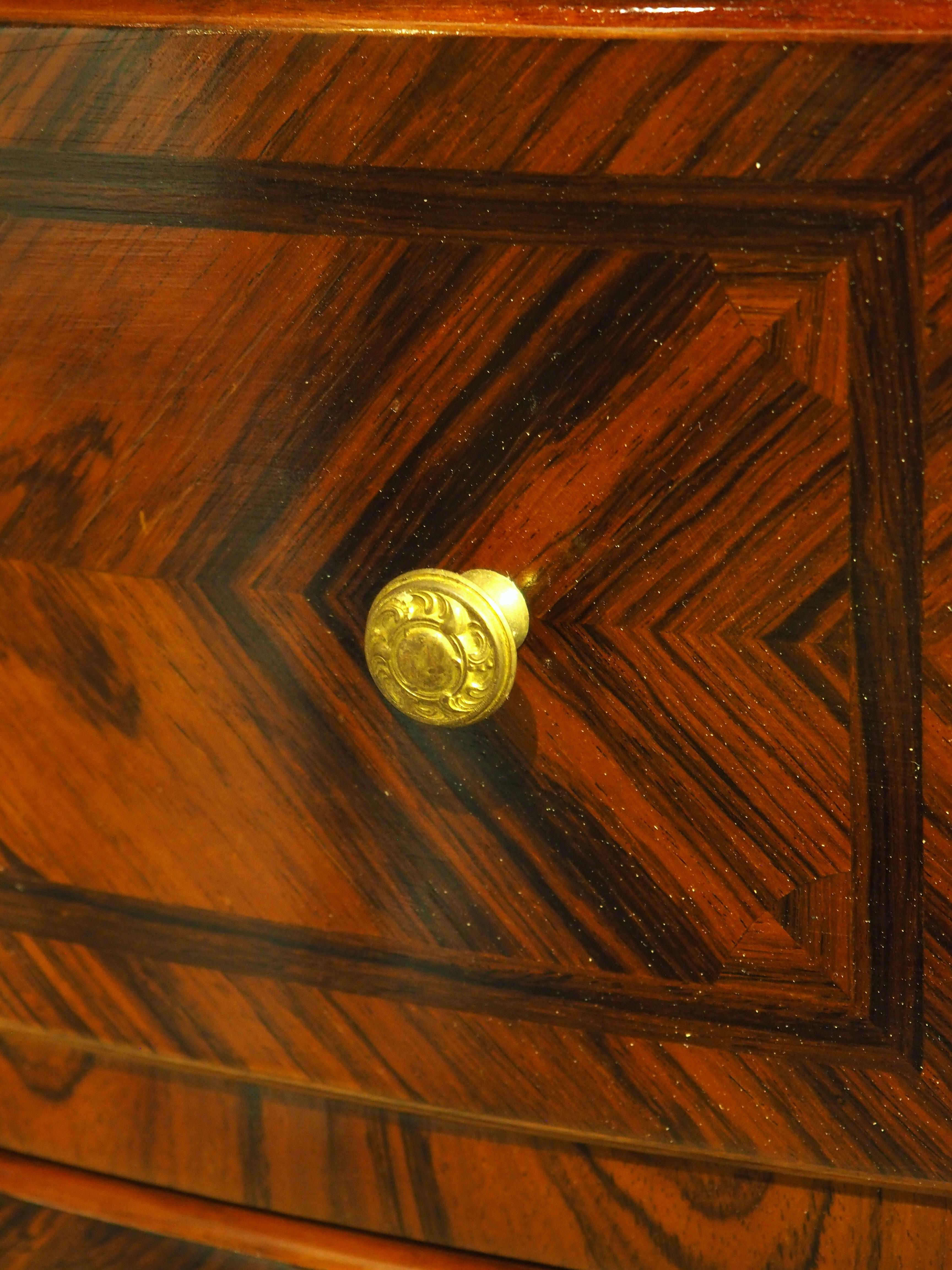 Questa cassettiera francese risale al 1875 circa ed è in stile Regence, con ferramenta in bronzo dorato. L'impiallacciatura in parquet ha una ricca lucentezza e una calda tonalità marrone accentuata dalle venature del legno scuro. Ognuno dei tre