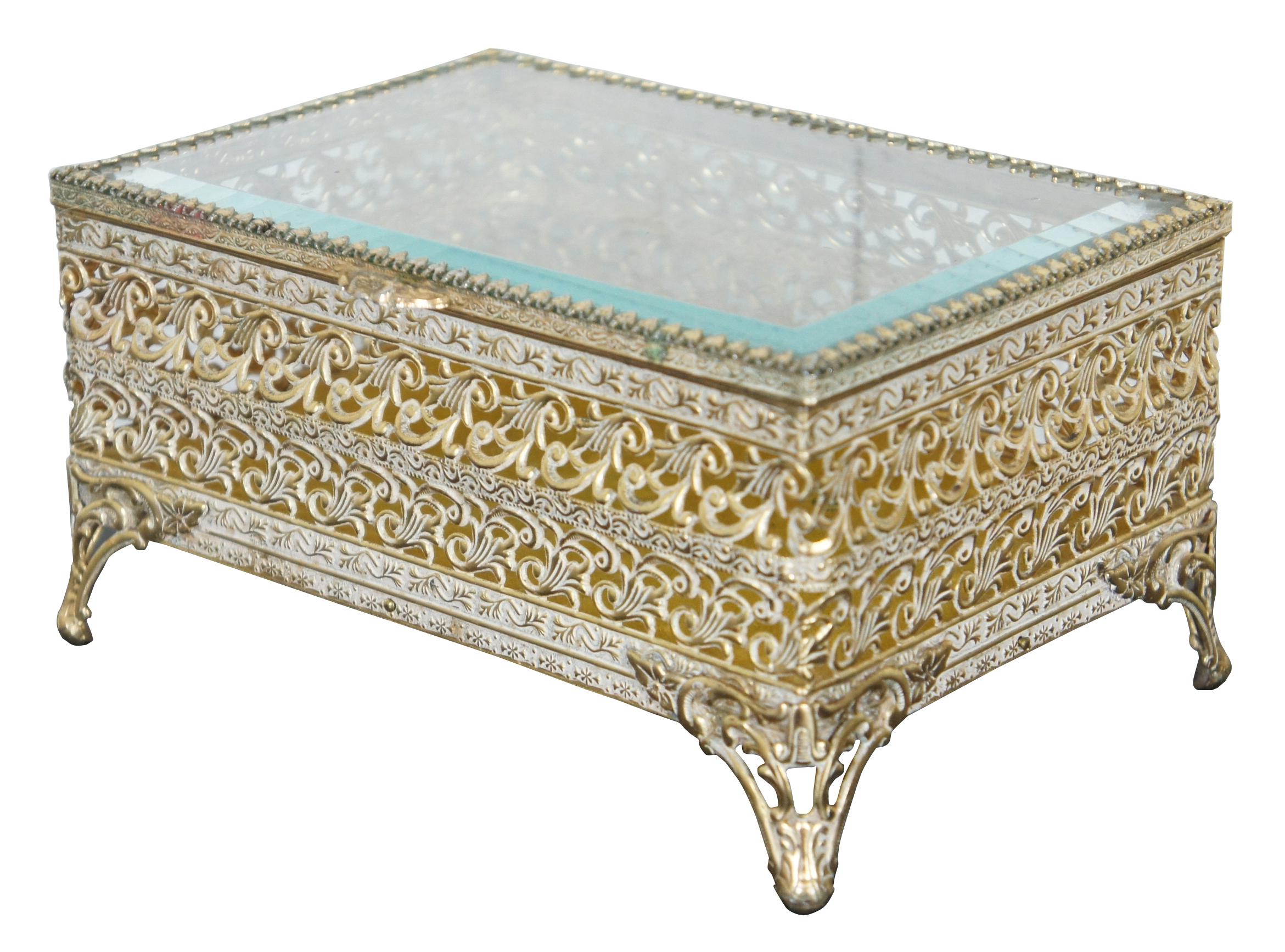 Antique brass filigree trinket/jewelry box with beveled glass lid, and footed with ornate design.
 
