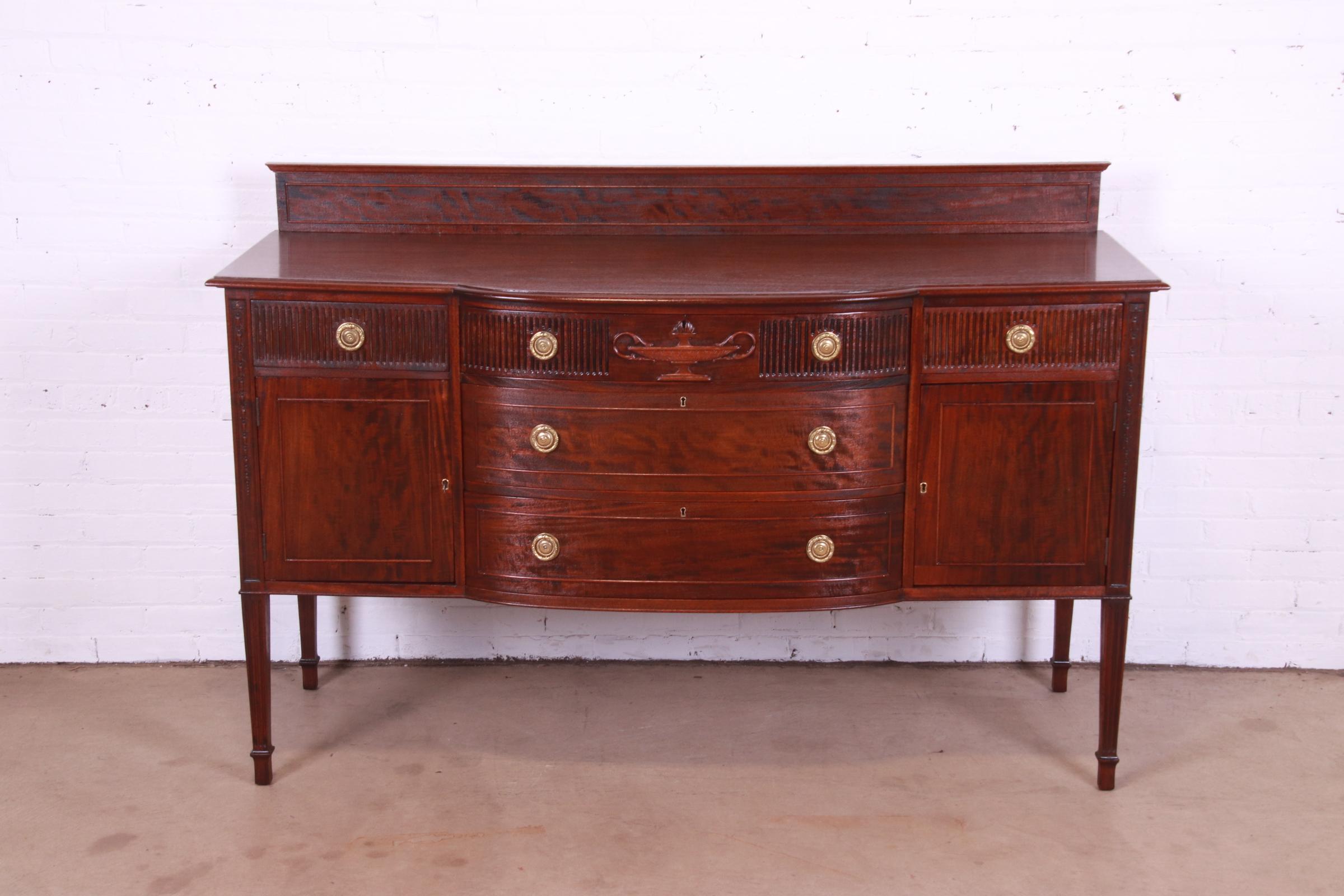 A gorgeous antique French Regency Louis XVI style bow front sideboard, buffet, or bar cabinet

In the manner of John Widdicomb

USA, Circa 1920s

Carved mahogany, with original brass hardware. Cabinets lock, and key is included.

Measures: