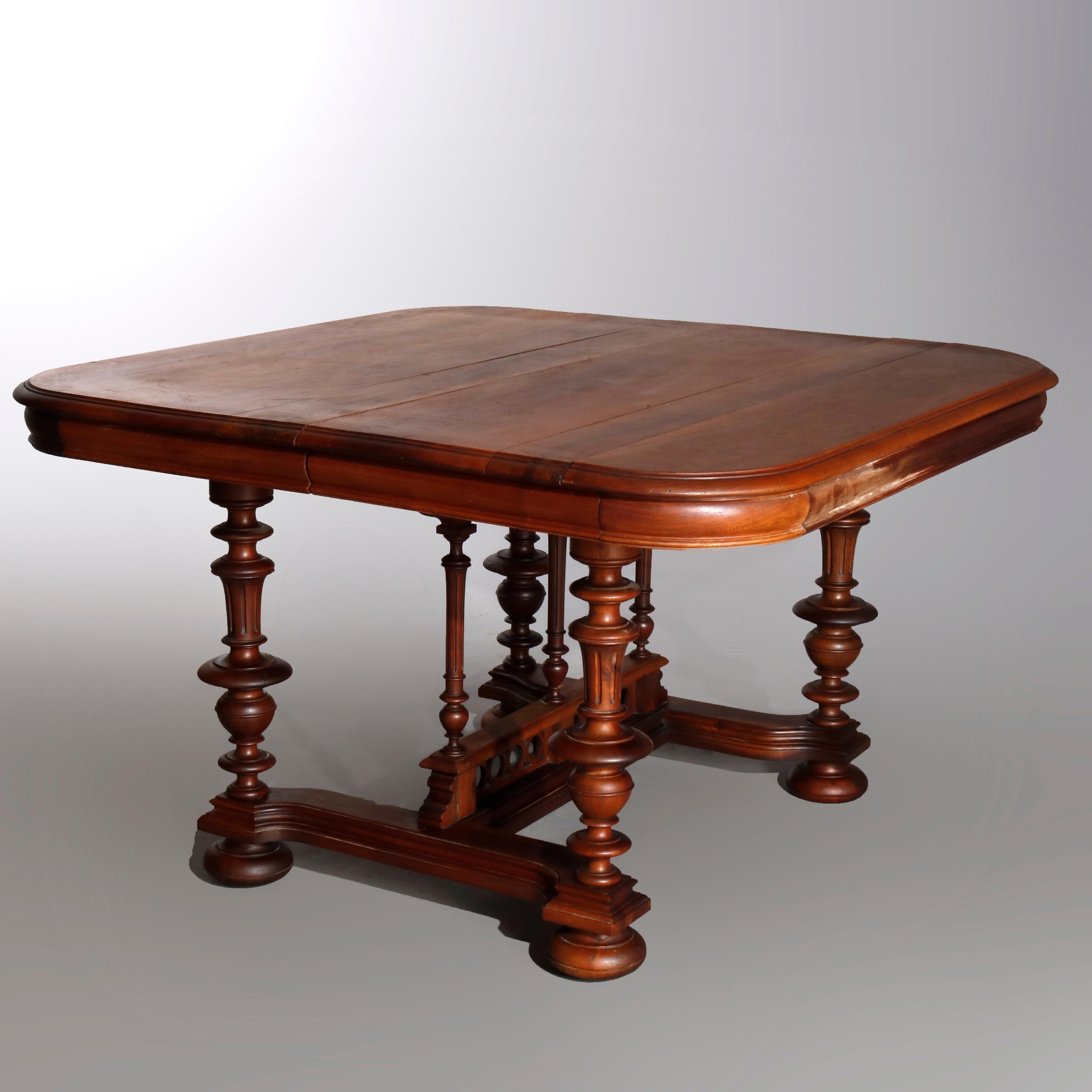 Antique French Renaissance carved walnut extension dining table with curved corner top over deep skirt, raised on turned urn form legs with H-stretcher having central turned column supports and bun feet, 19th century

Measures: 27.5