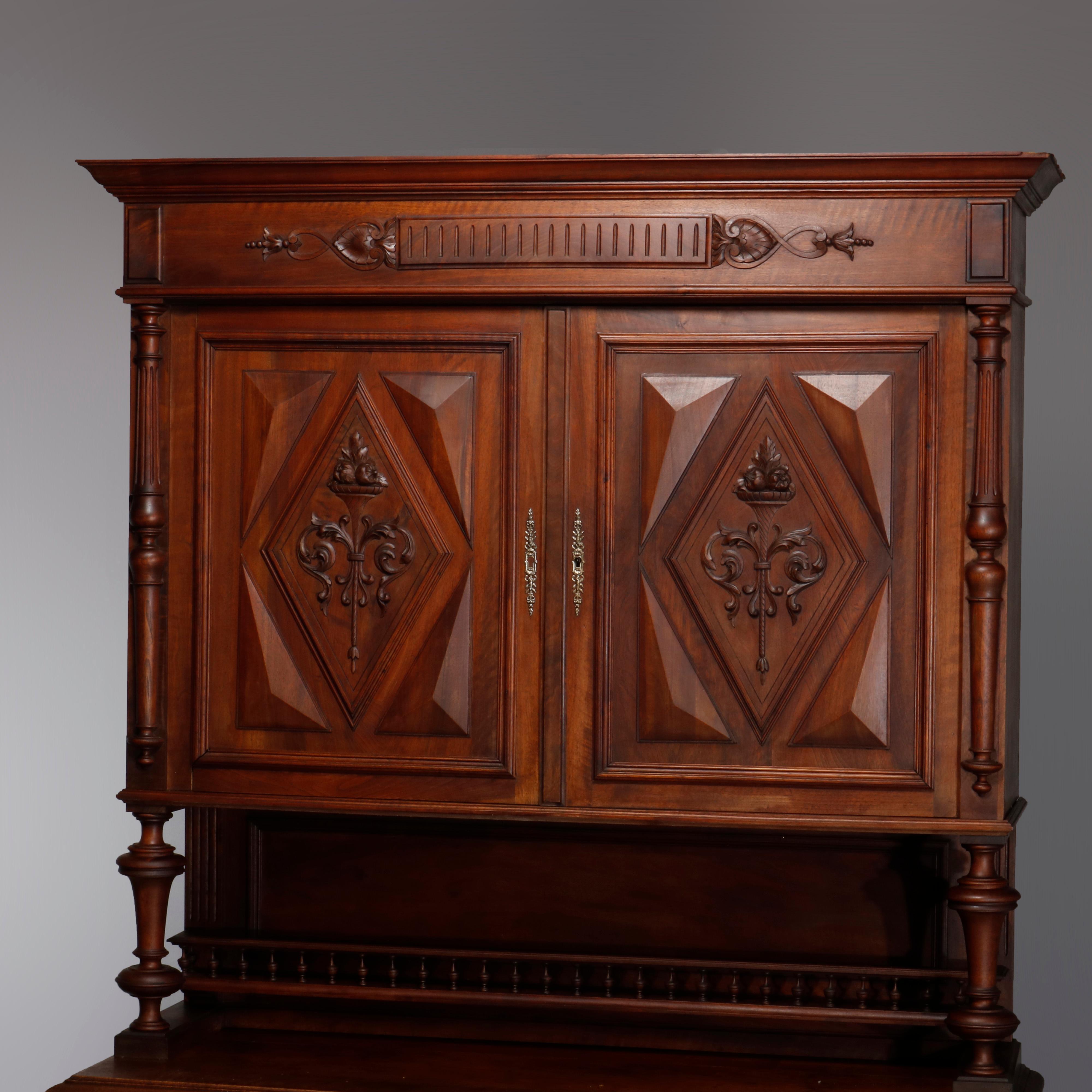 Armoire ancienne en noyer sculpté de la Renaissance française, avec une porte supérieure à deux battants présentant des éléments géométriques avec des réserves centrales de torchères à panier de fleurs, surmontant une porte inférieure à deux tiroirs