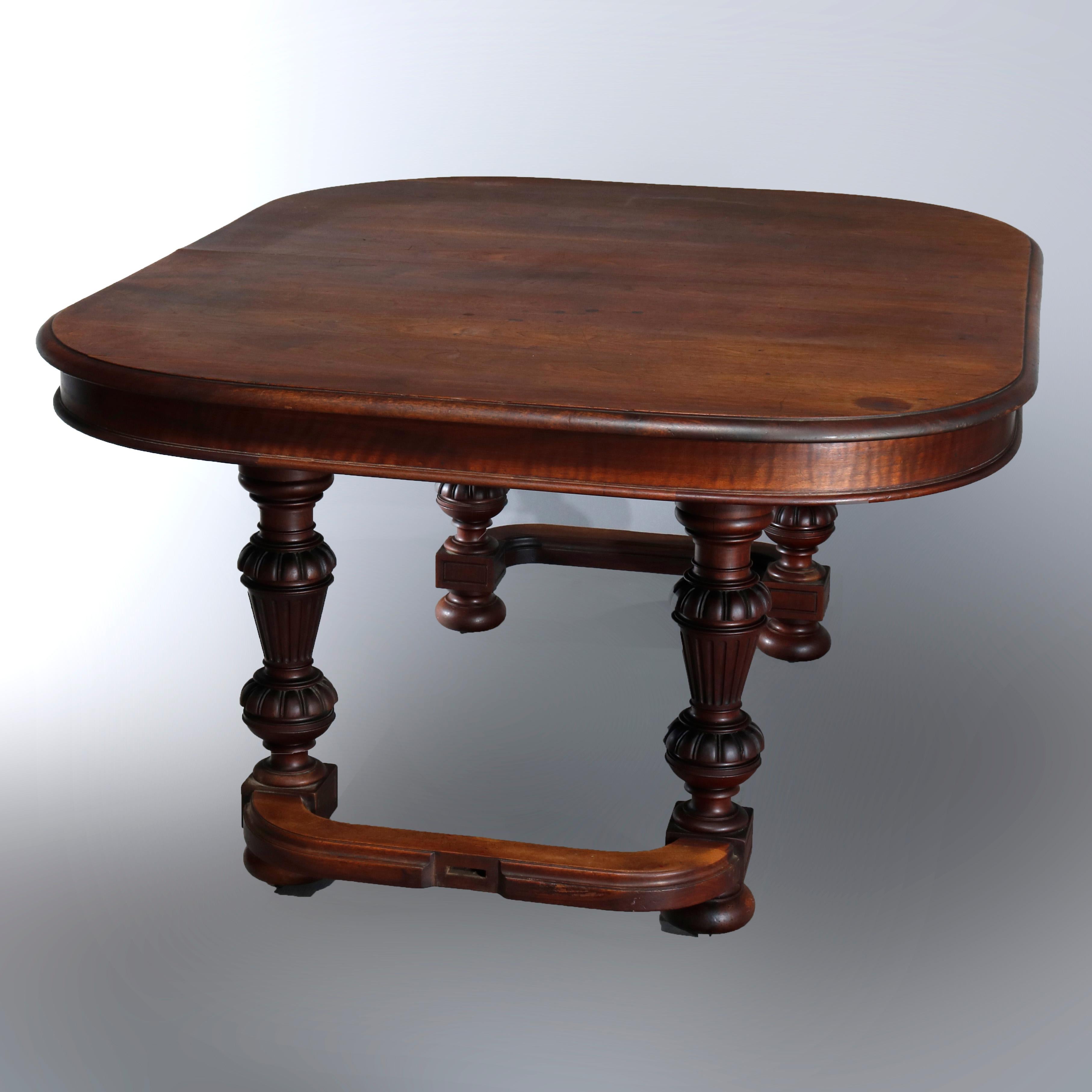 Antique French Renaissance carved walnut extension dining table with rounded corner top and deep skirt raised on turned urn form column legs and ball feet, 19th century

Measures: 28.25