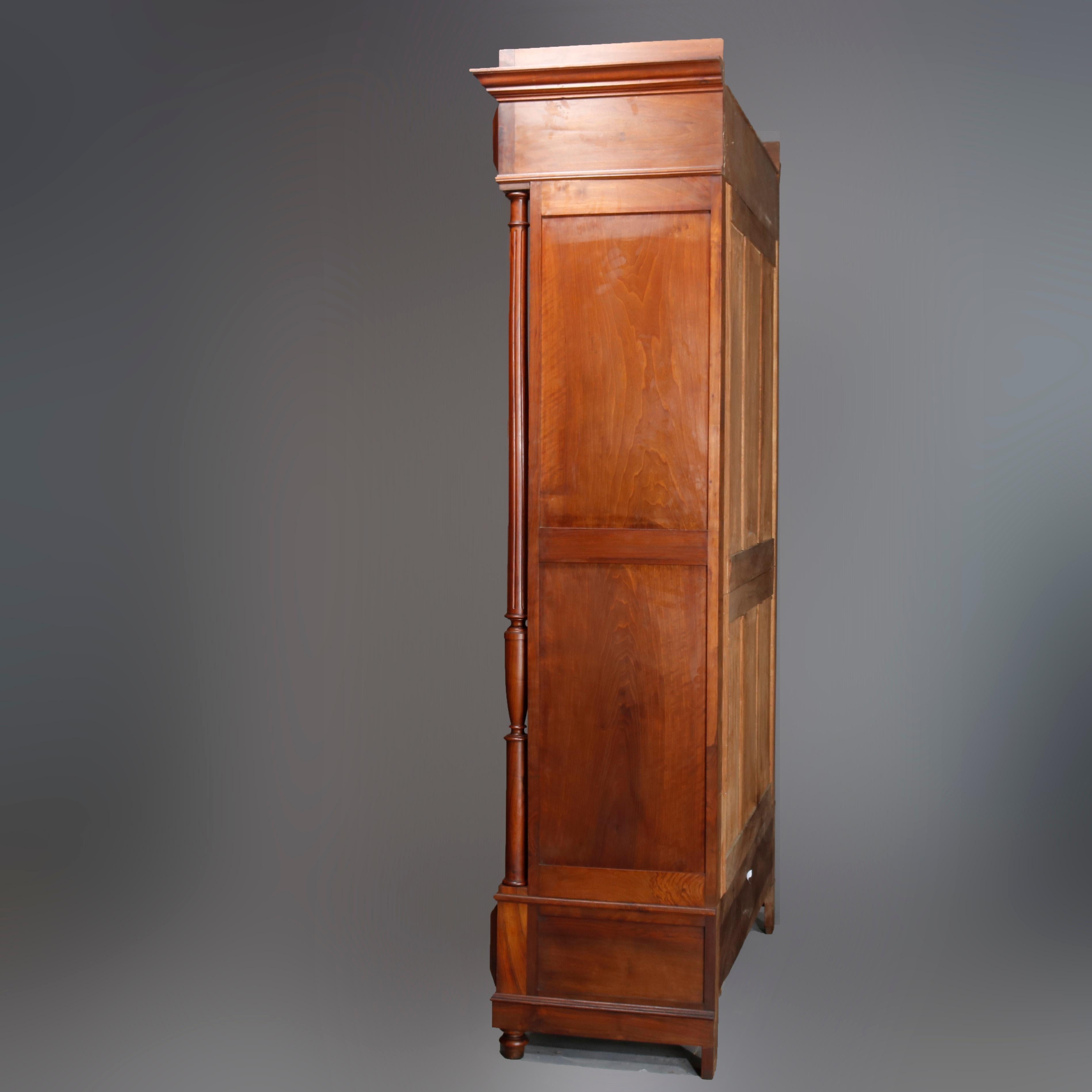 Antique French Renaissance carved walnut double door Armoire with fluted frieze, surmounting beveled mirrors with flanking full turned columns, single lower long drawer, pyramidal elements, raised on Marseille bun feet, 19th century.

Measures: