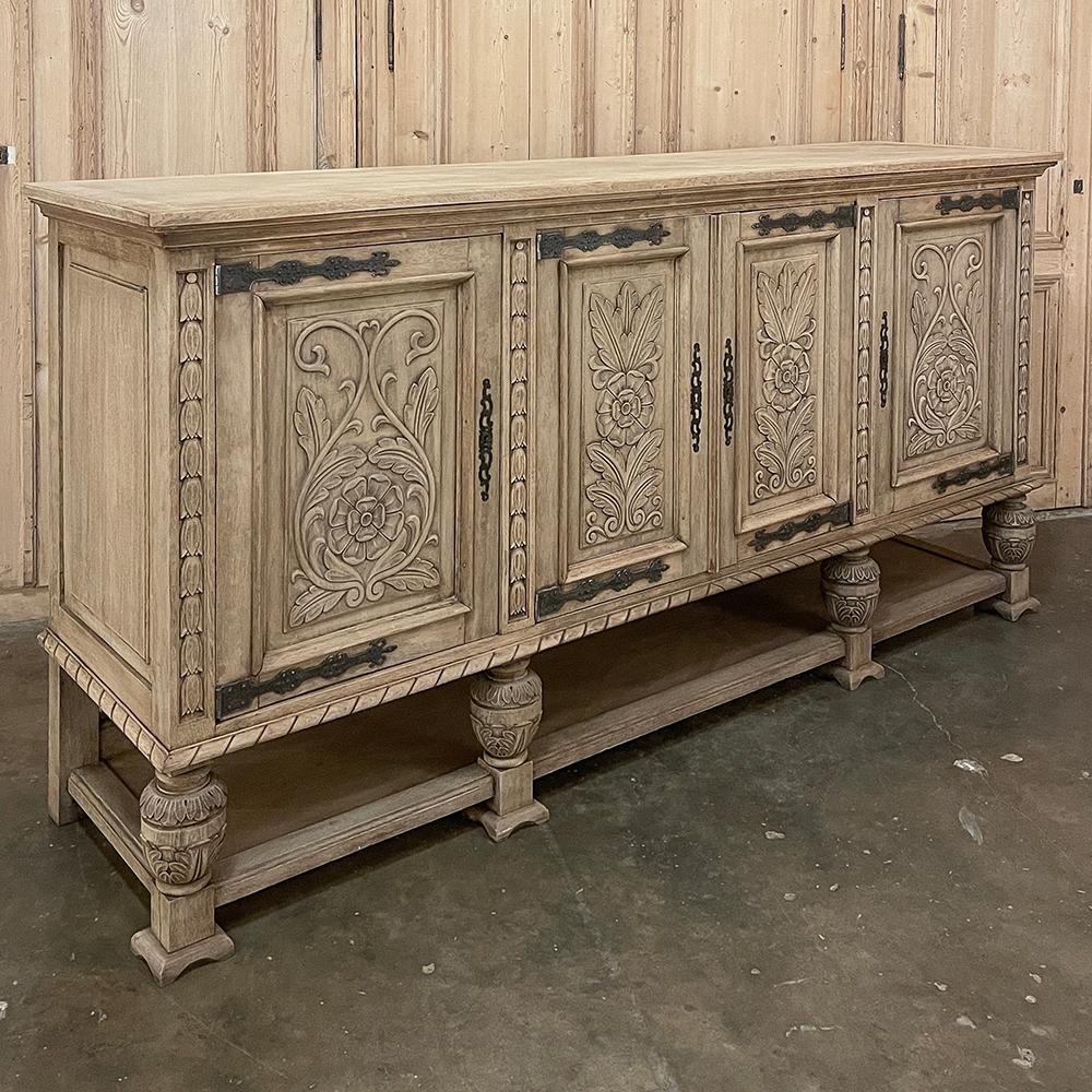 Antique French Renaissance Raised Buffet in Stripped Oak was hand-crafted and carved from solid oak and designed to last for generations!  Ideal for any room that needs stylish storage with a masculine bent, it features four finely carved doors