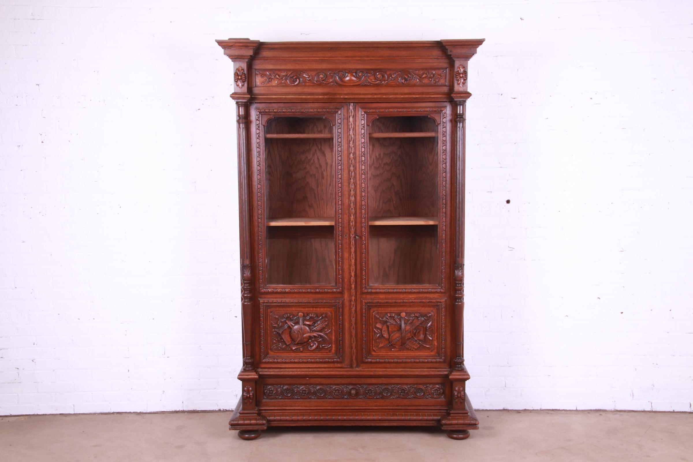 A gorgeous French Renaissance Revival bibliotheque bookcase cabinet

France, Circa 1900

Carved oak, with glass front doors. Cabinet locks, and key is included.

Measures: 53