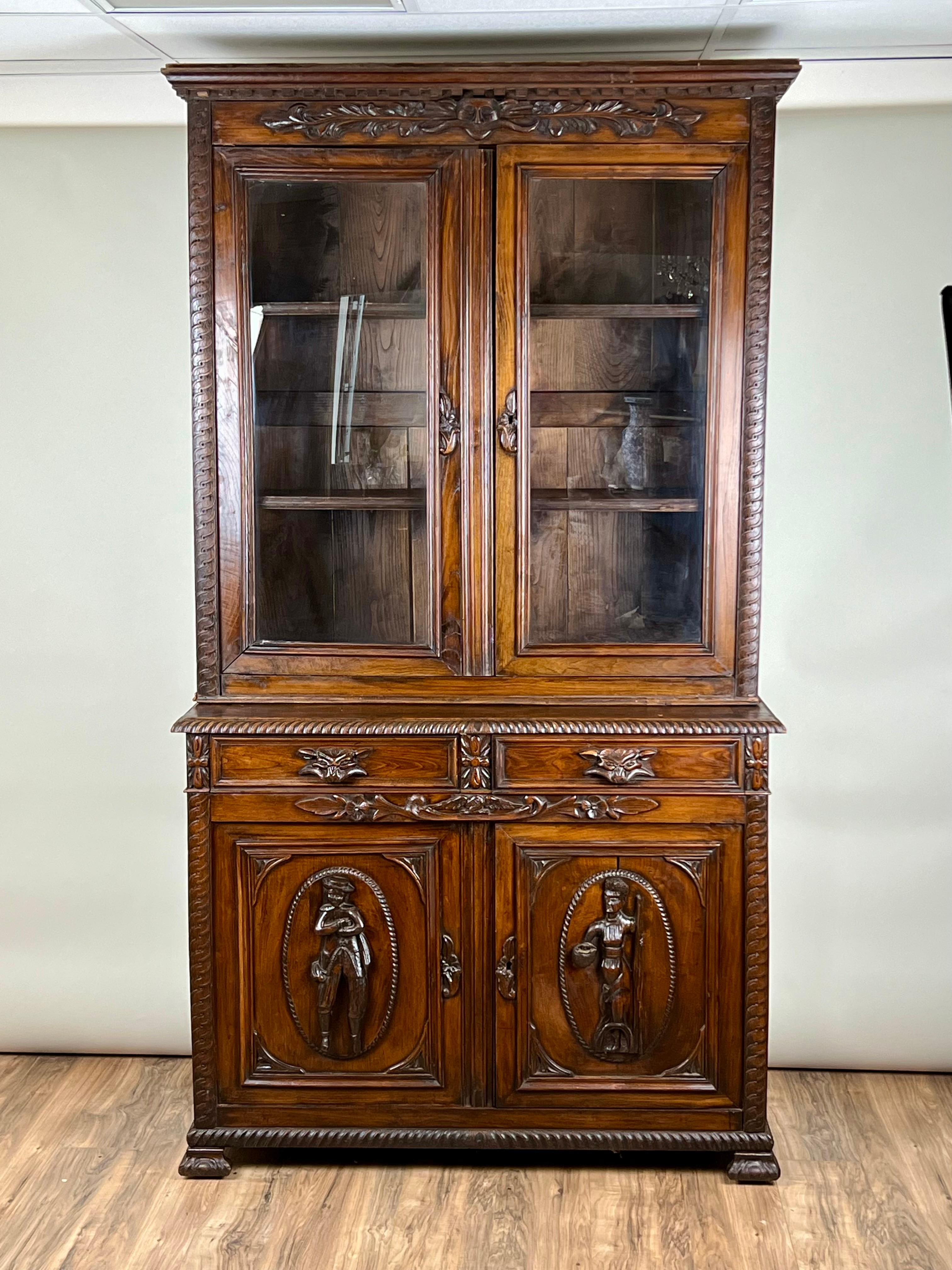 Cette bibliothèque à dos d'âne de style néo-Renaissance française du milieu du XIXe siècle illustre la grandeur et la complexité décorative de l'époque. La pièce est fabriquée en châtaignier, un bois qui a développé une patine riche et profonde au