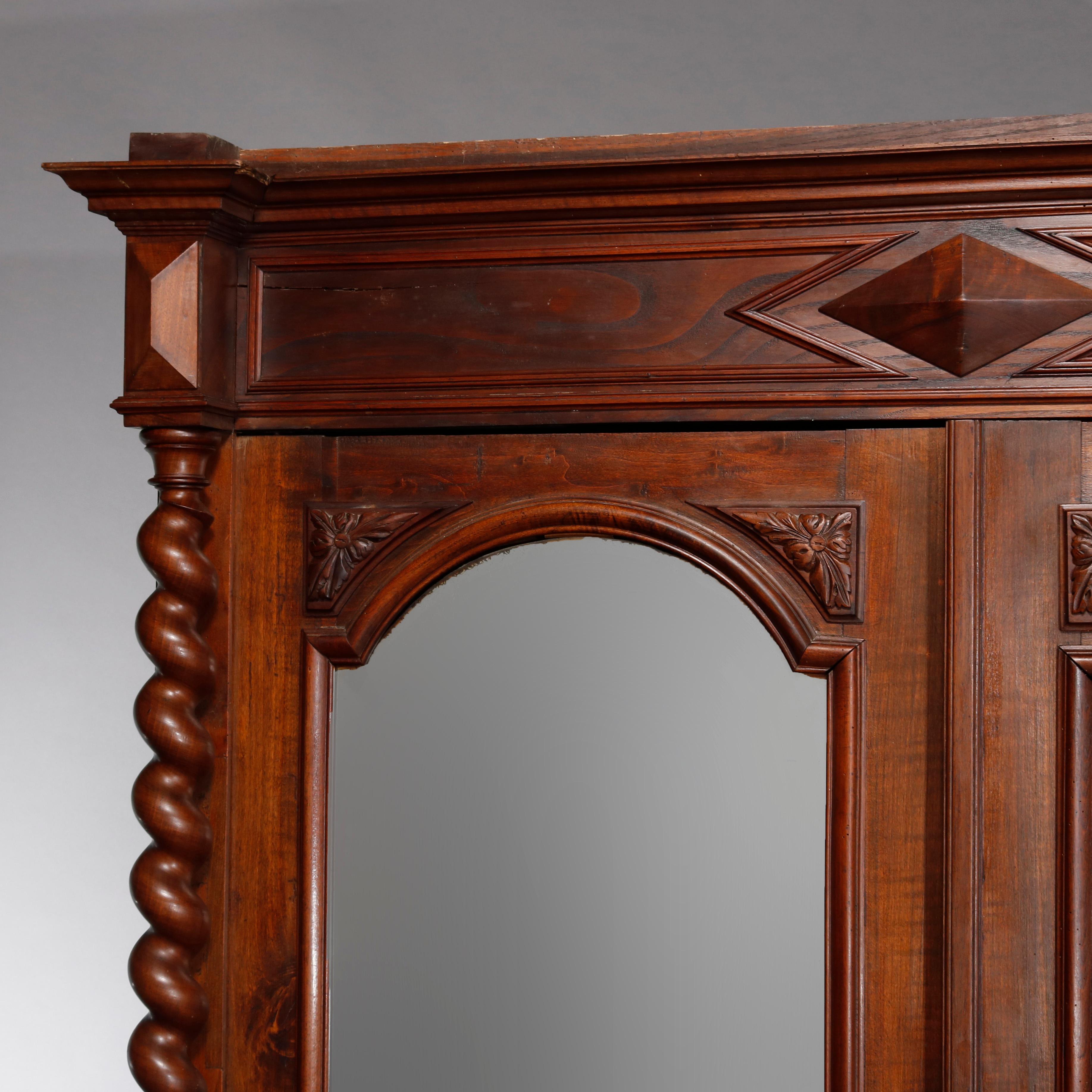 Antique French Renaissance carved walnut double door armoire with arched beveled mirrors, full barley twist columns, pyramidal elements, single lower drawer raised on bun feet, 19th century

Measures- 89.5