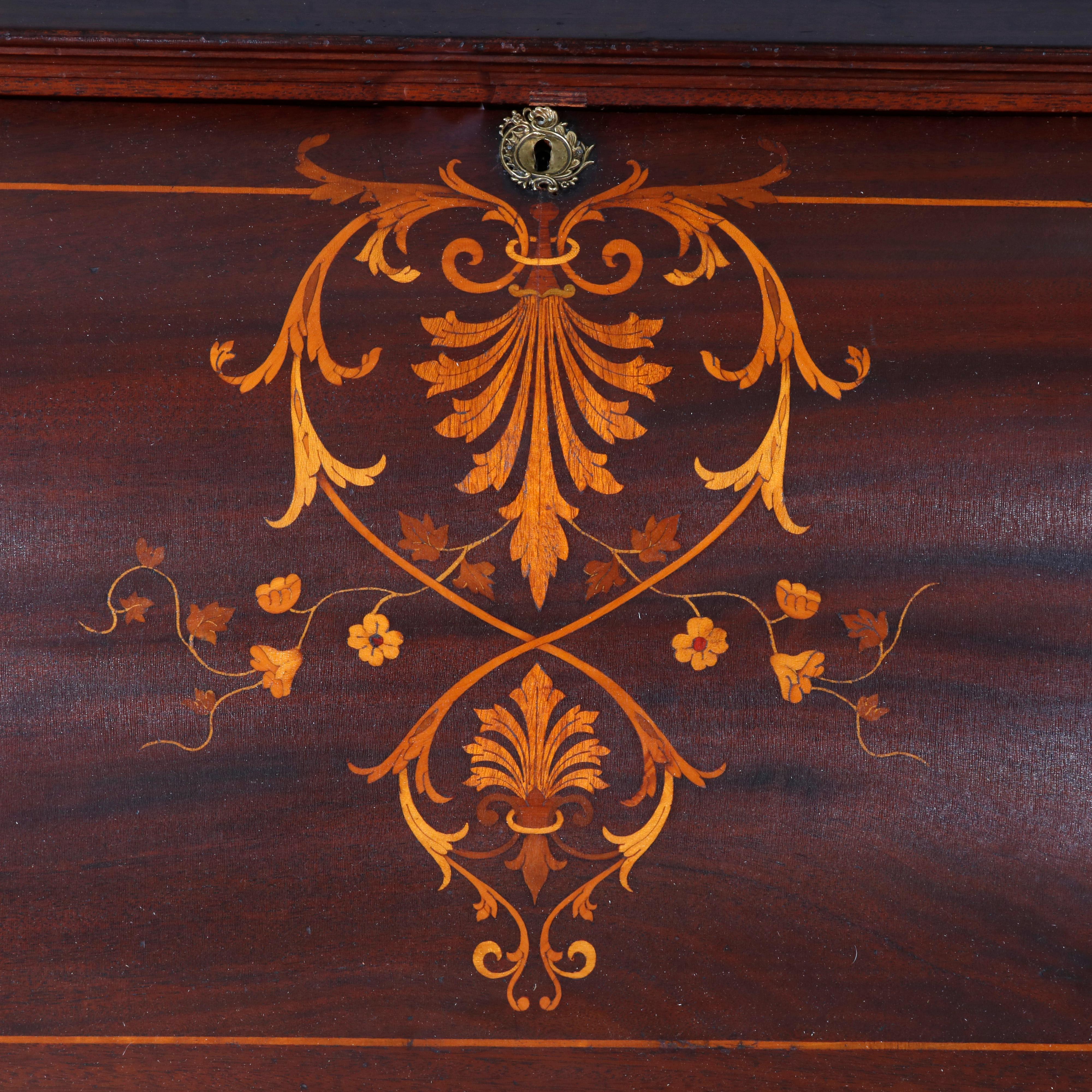 An antique desk in the manner of RJ Horner offers French styling with pierced brass gallery over flame mahogany case having allover foliate satinwood marquetry inlay, drop front writing surface opening to small drawers and pigeon holes surmounting