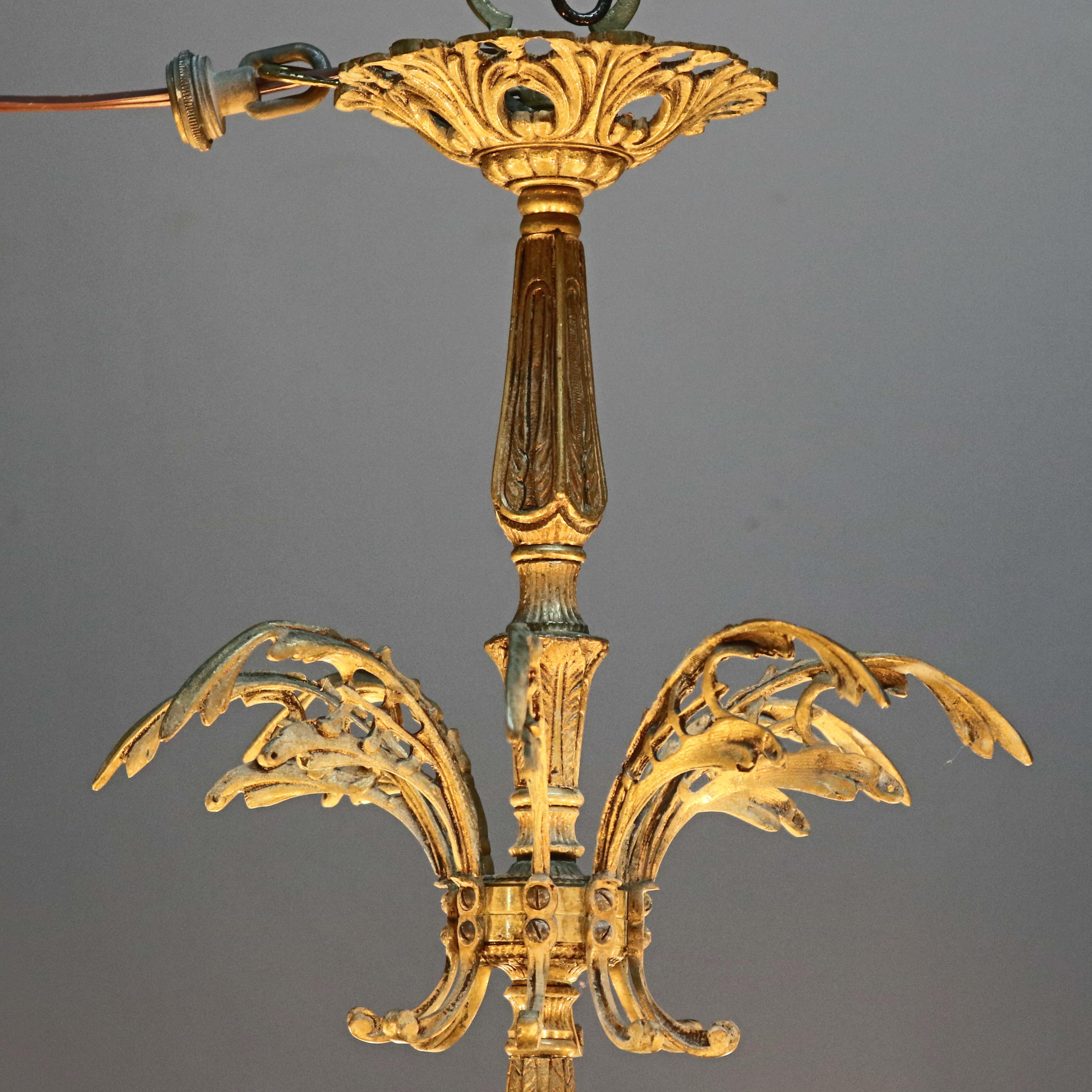 An antique French Rococo chandelier offers bronze frame with pierced font and twelve s-scroll foliate form arms terminating in candle lights and having hanging crystal prisms, c1903.

Measures: 25.25