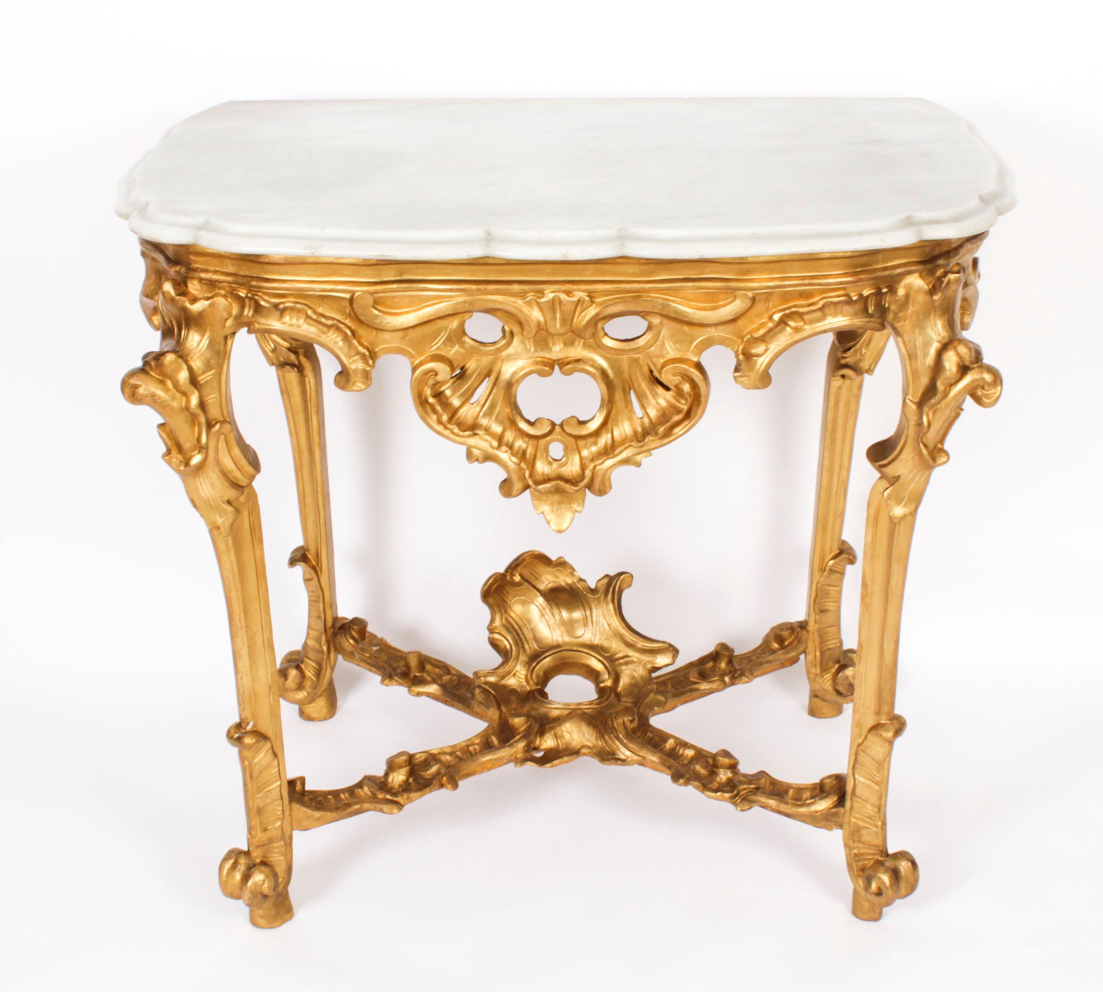 Table console en bois doré sculpté d'époque Rococo du 18ème siècle, datant d'environ 1770.

Cette console en bois doré finement sculptée est surmontée d'un plateau rectangulaire en marbre de Carrare de forme exquise, au-dessus d'une frise décorative