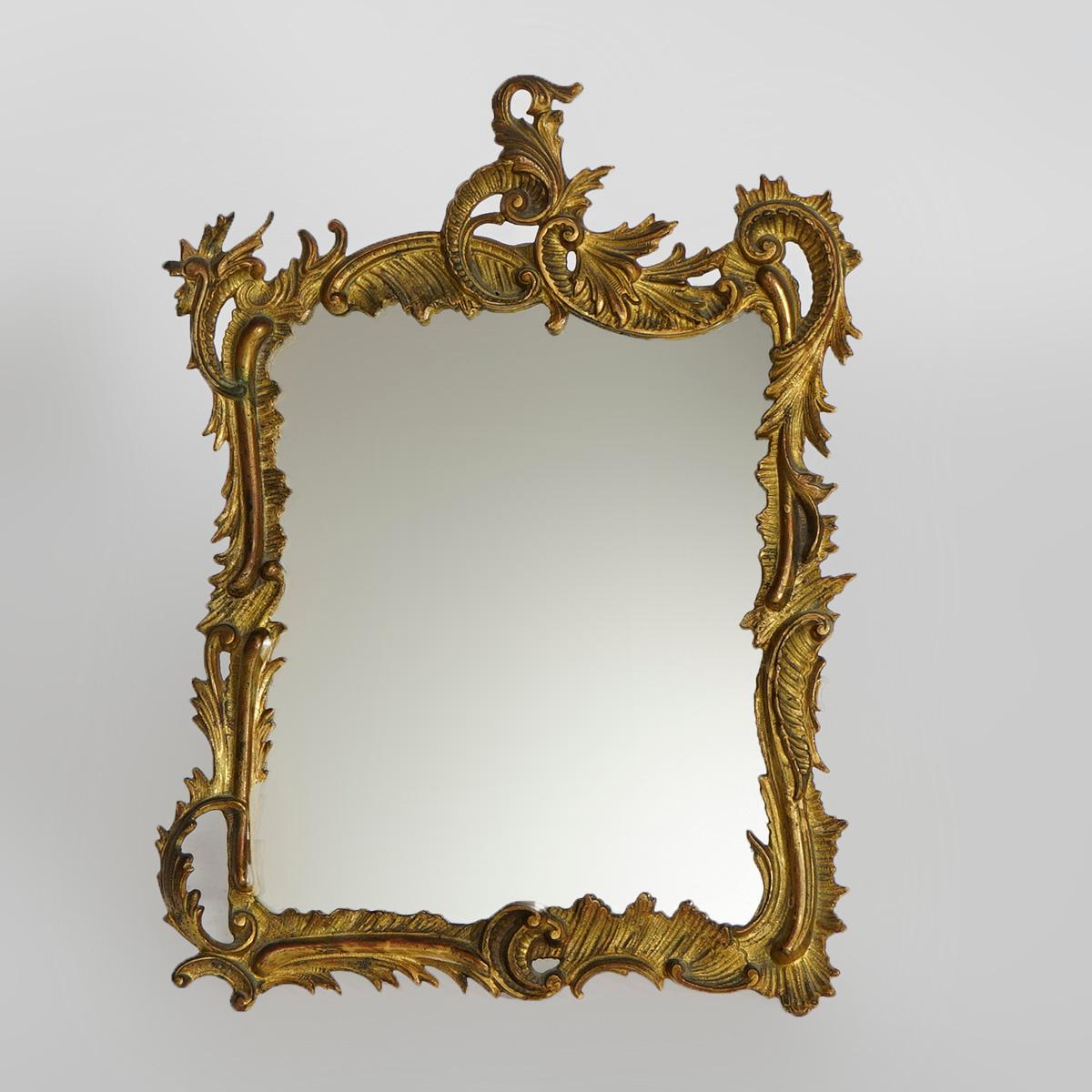 An antique French Rococo style vanity or dresser mirror offers cast bronze frame in foliate form with mirror having easel back, 19th century.

Measures- 17.75''H x 13.25''W x .5''D.

Catalogue Note: Ask about DISCOUNTED DELIVERY RATES available to