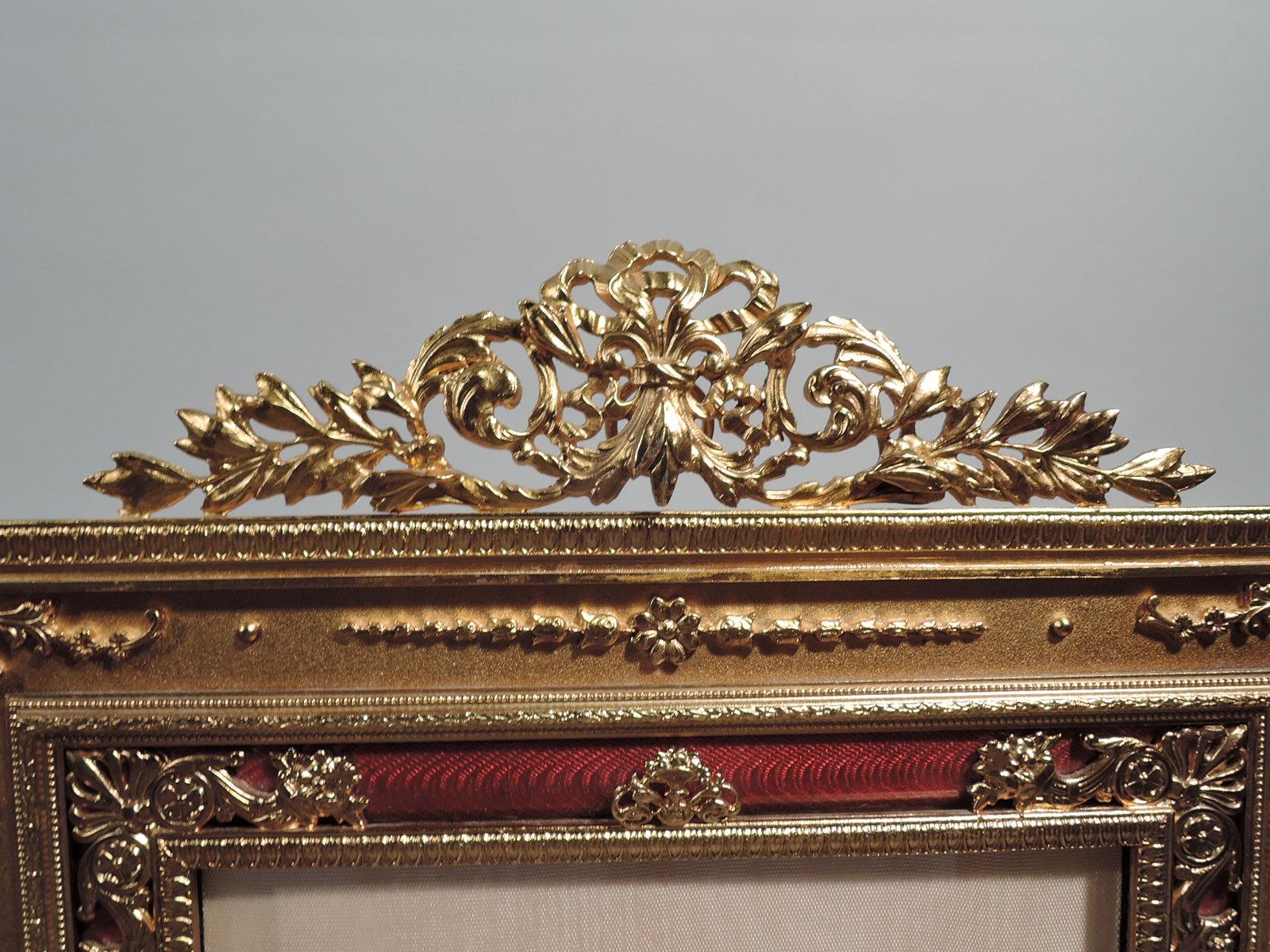 Turn-of-the-century French gilt bronze picture frame. Rectangular window in same surround with raised leaf-and-dart, imbricated leaf, and beaded borders. Red guilloche border and applied and pierced flower baskets, cornucopias, bouquets and shells.