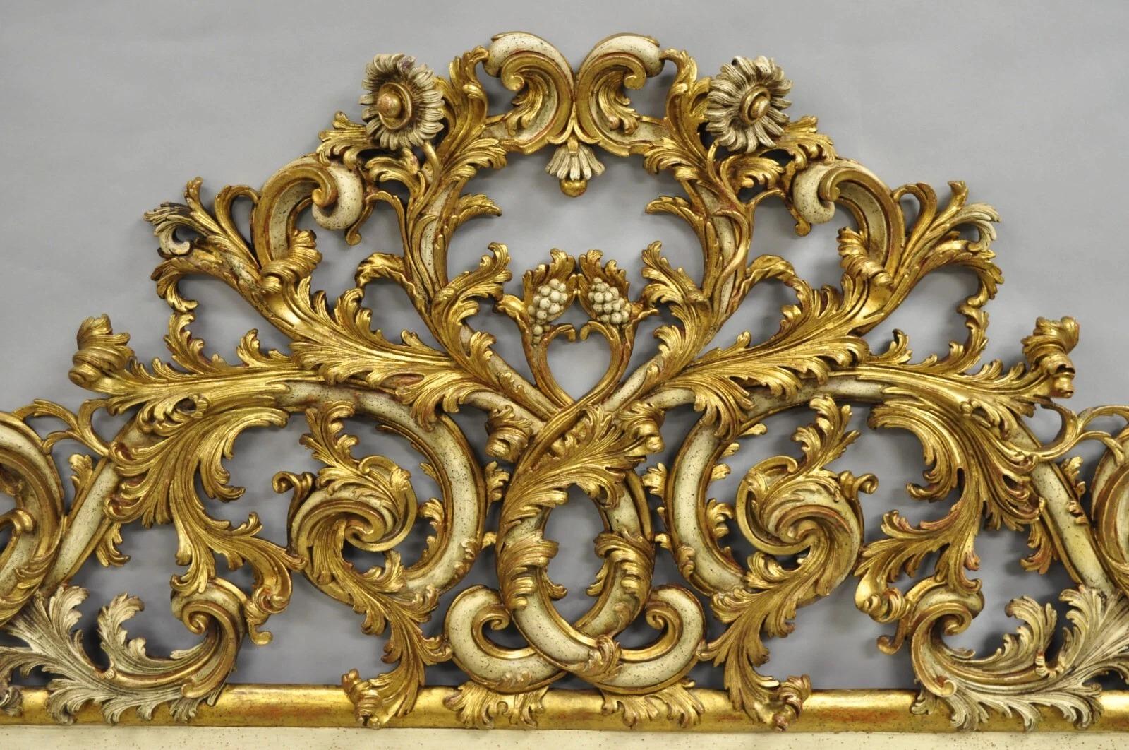 Antique French Rococo Gold Giltwood Carved Wood Italian King Size Bed Headboard. L'articolo presenta una struttura in legno massiccio, splendide volute di foglie d'acanto intagliate a rilievo, finiture dipinte in crema e dorate, con fiori sulla