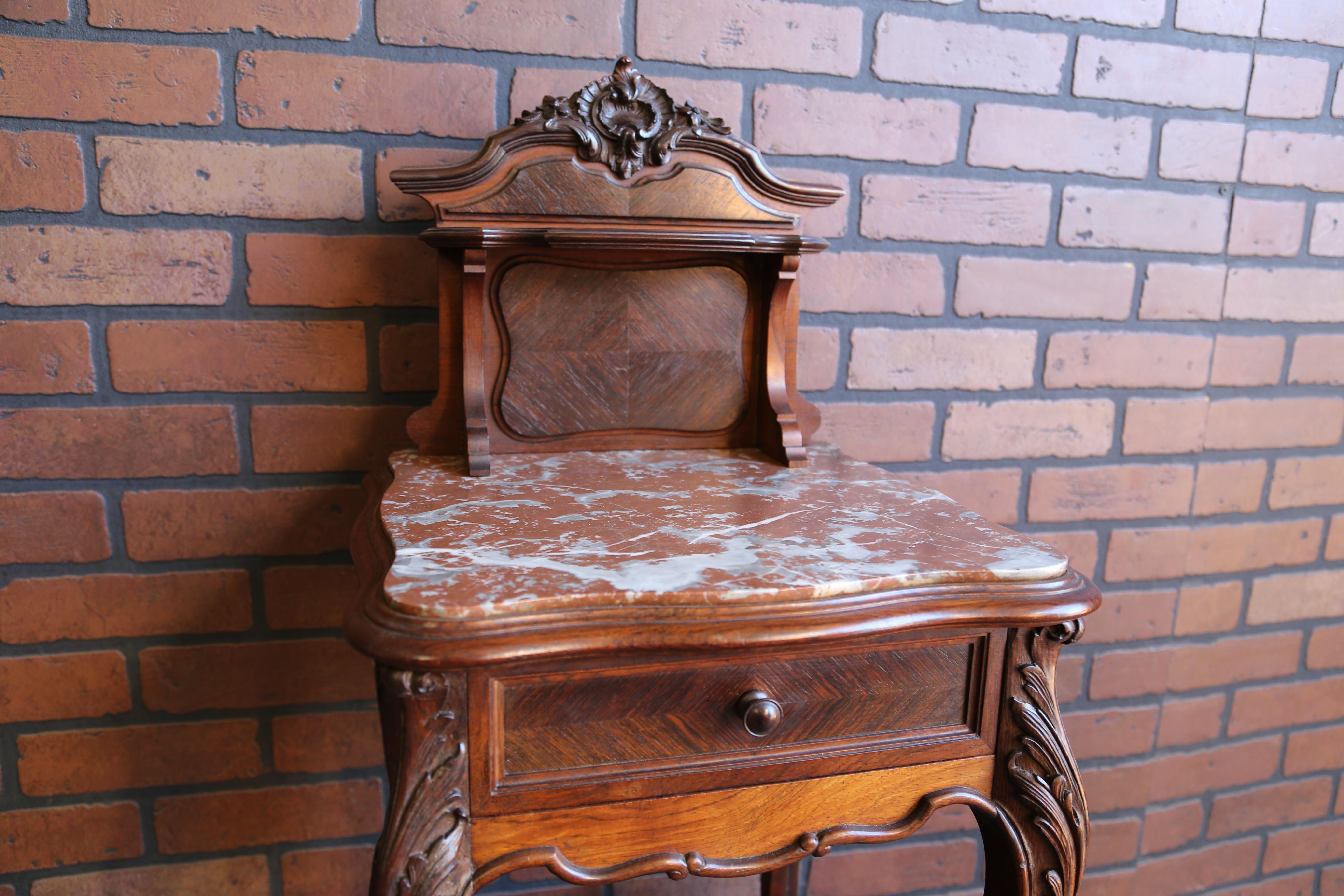 Antique French nightstand with marble top. This nightstand is oh so sweet. The carved pediment adorning the top of rococo back splash is the perfect crowning touch. Love the unique design featuring shapely legs connecting the top to the marble lined