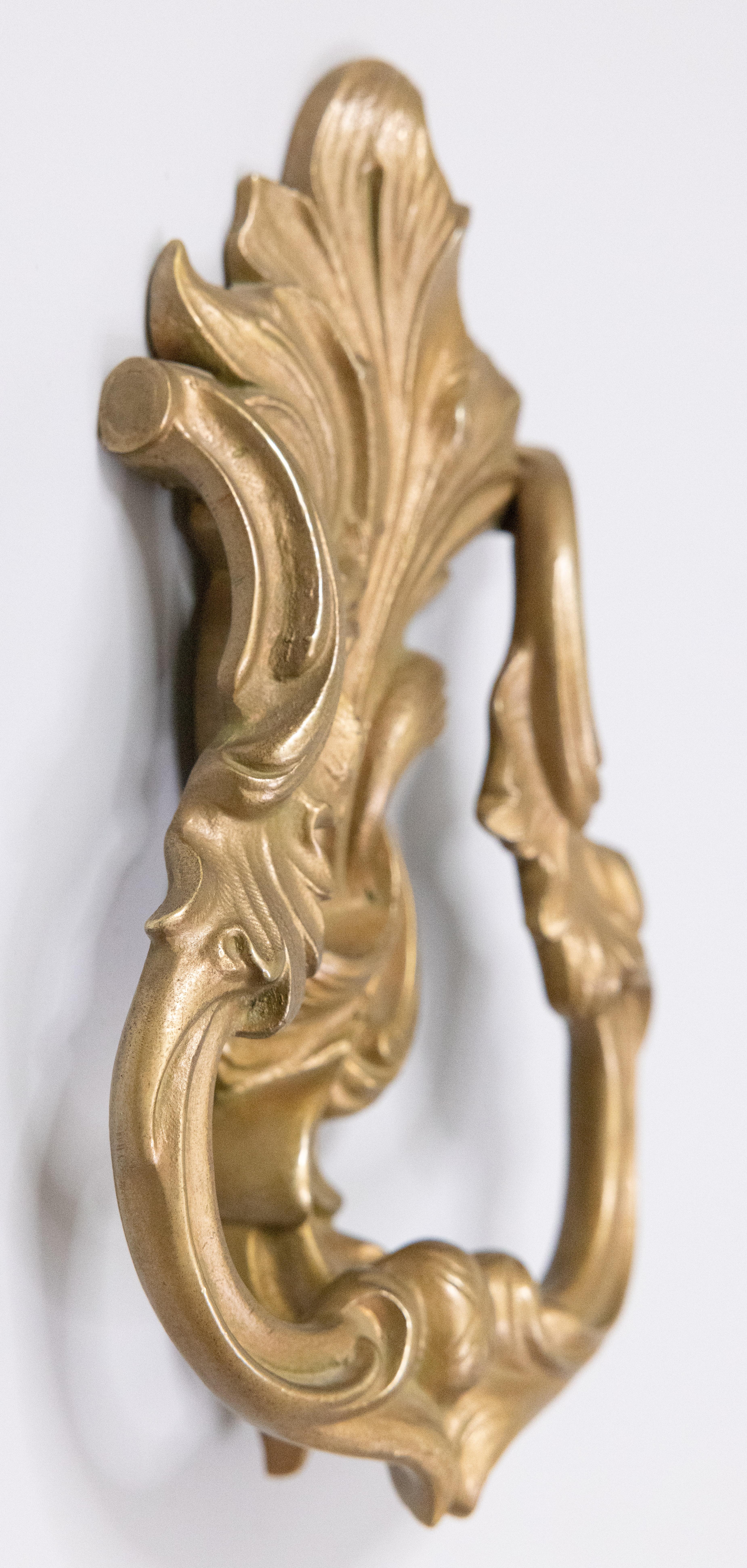 A gorgeous antique French gilded bronze Rococo style door knocker. This beautiful door knocker is solid and heavy with ornate scrolling leaves in a lovely gilt patina.