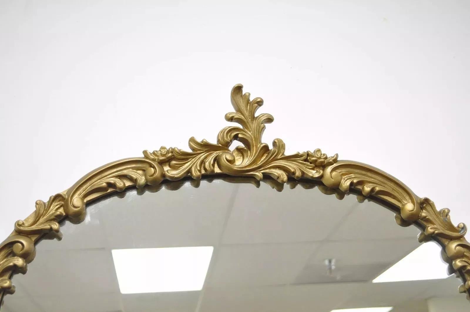Miroir mural ancien de style rococo français en bois doré et gesso à volutes feuillues. Circa Early 20th Century. Dimensions : 42,5
