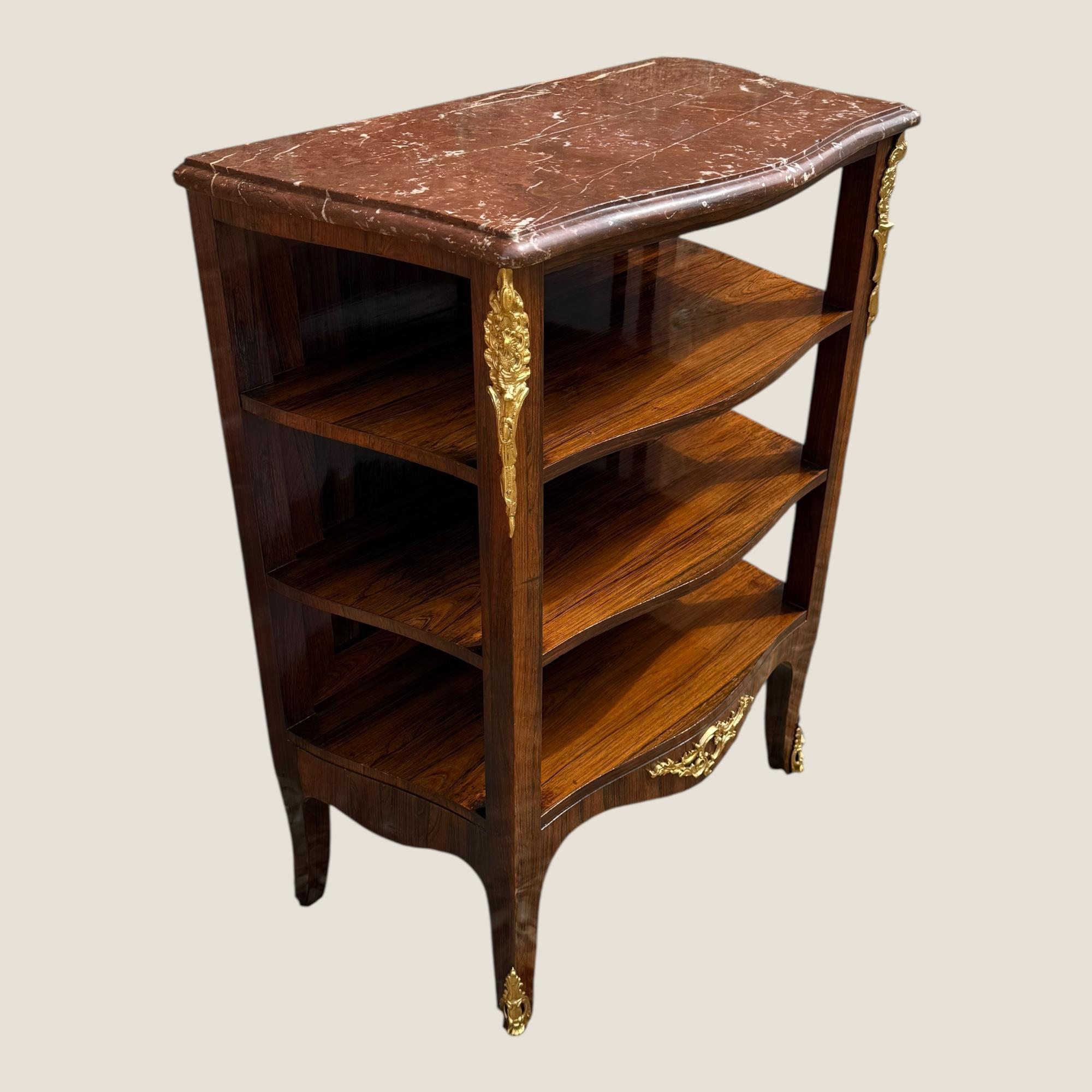 Qui abbiamo un antico mobile laterale in palissandro francese della fine del XIX secolo, circa 1890, con 3 ripiani per libri e altri oggetti e decorazioni in ottone con montatura Ormolu. Il marmo è di un bel colore rosso porpora con venature bianche