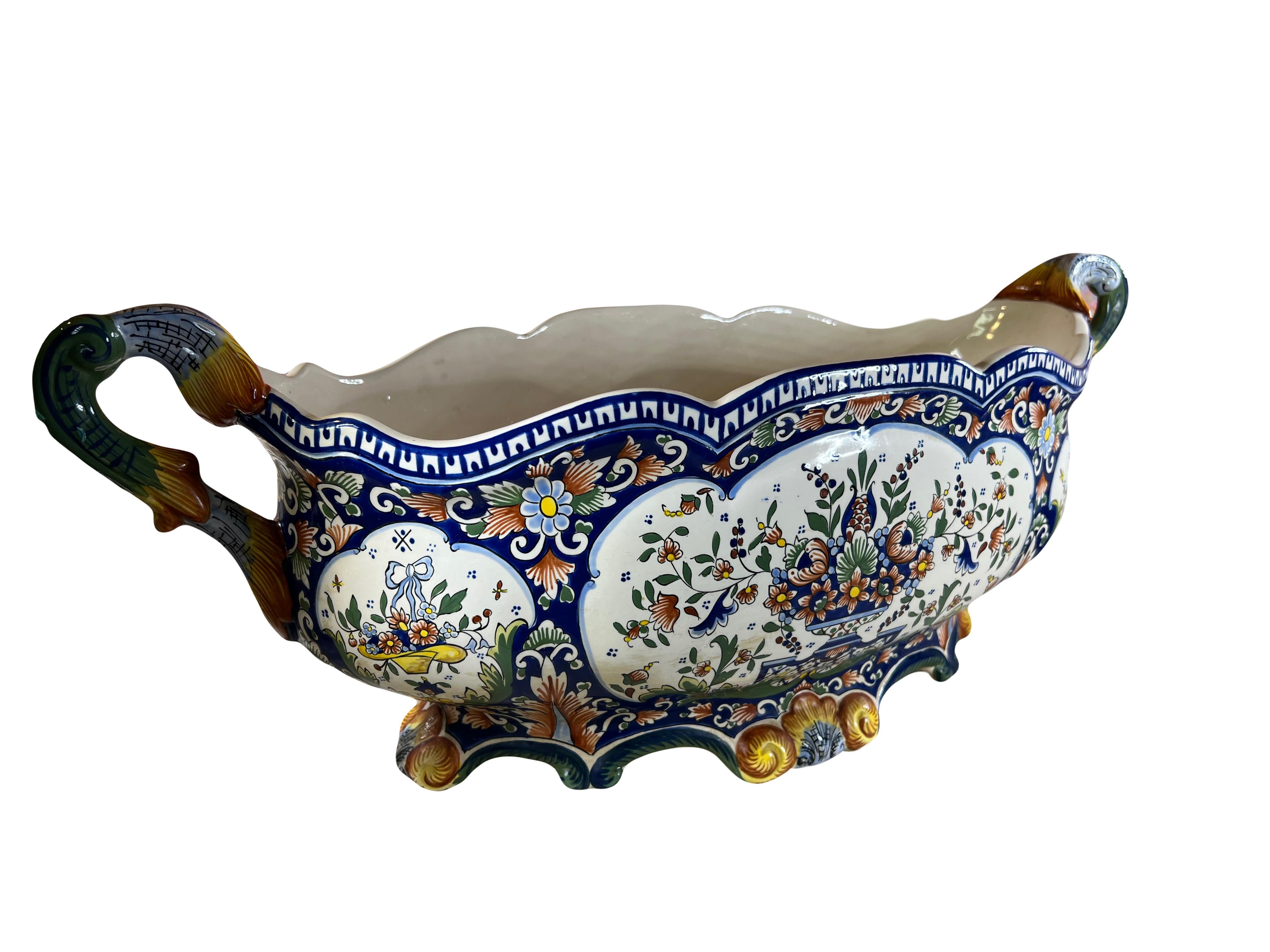 Enhance your collection with this stunning antique French faience jardiniere/cachepot, a testament to the exquisite craftsmanship of Rouen ceramics. Dating to circa 1900, this large and elegant piece is meticulously hand-painted with intricate