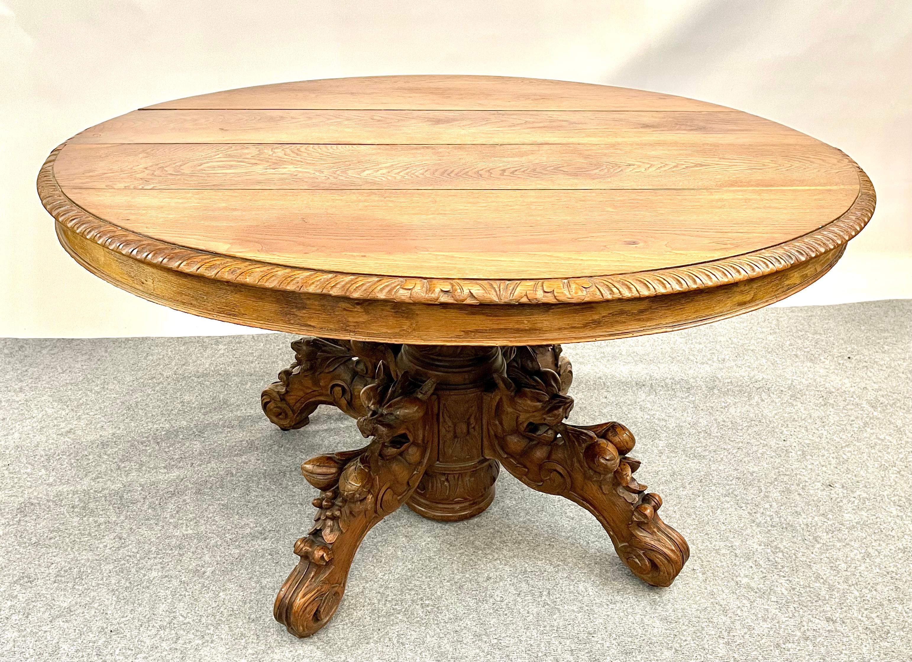 This classic hunting or Black Forest dining table is from France and dates to the late 1800's. 

This one is unusually nice with intricate carvings on the feet. The table is made from solid and veneered oak finished to a warm dark color. It is in