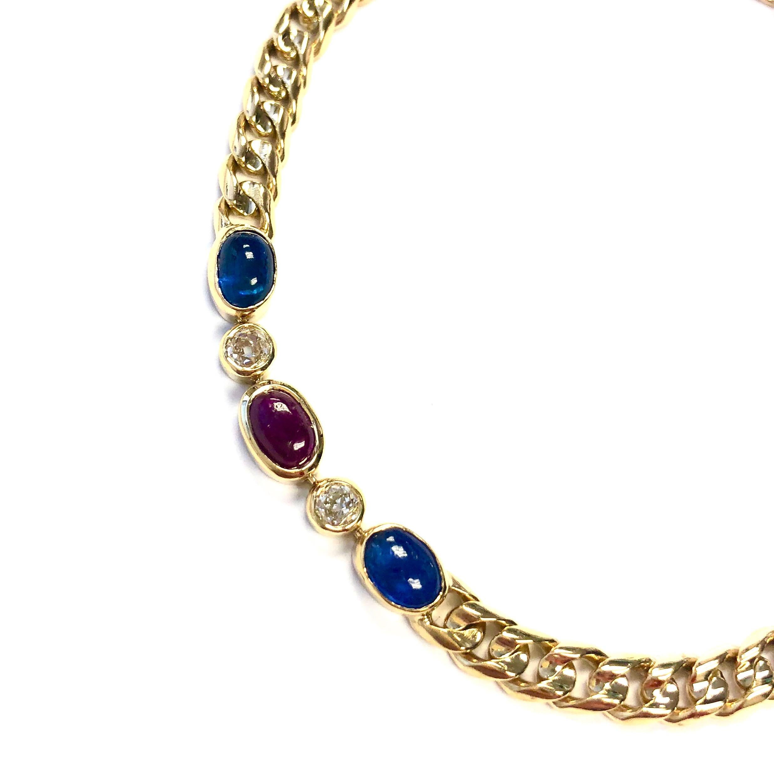 Antique French bracelet crafted in 18K yellow gold, featuring three sections of bezel set gemstones connected by gold curbed link chains. Each section has three oval cabochon cut rubies and sapphires with old mine cut diamondds in between them.