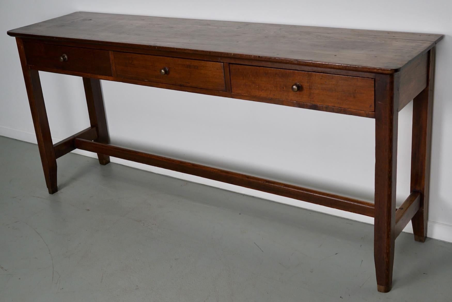 Cette élégante table a été fabriquée en France à partir d'un vieil orme aux magnifiques veinures. Elle a une couleur chaude avec une brillance profonde et la table montre de nombreuses marques d'utilisation et a une grande patine. 