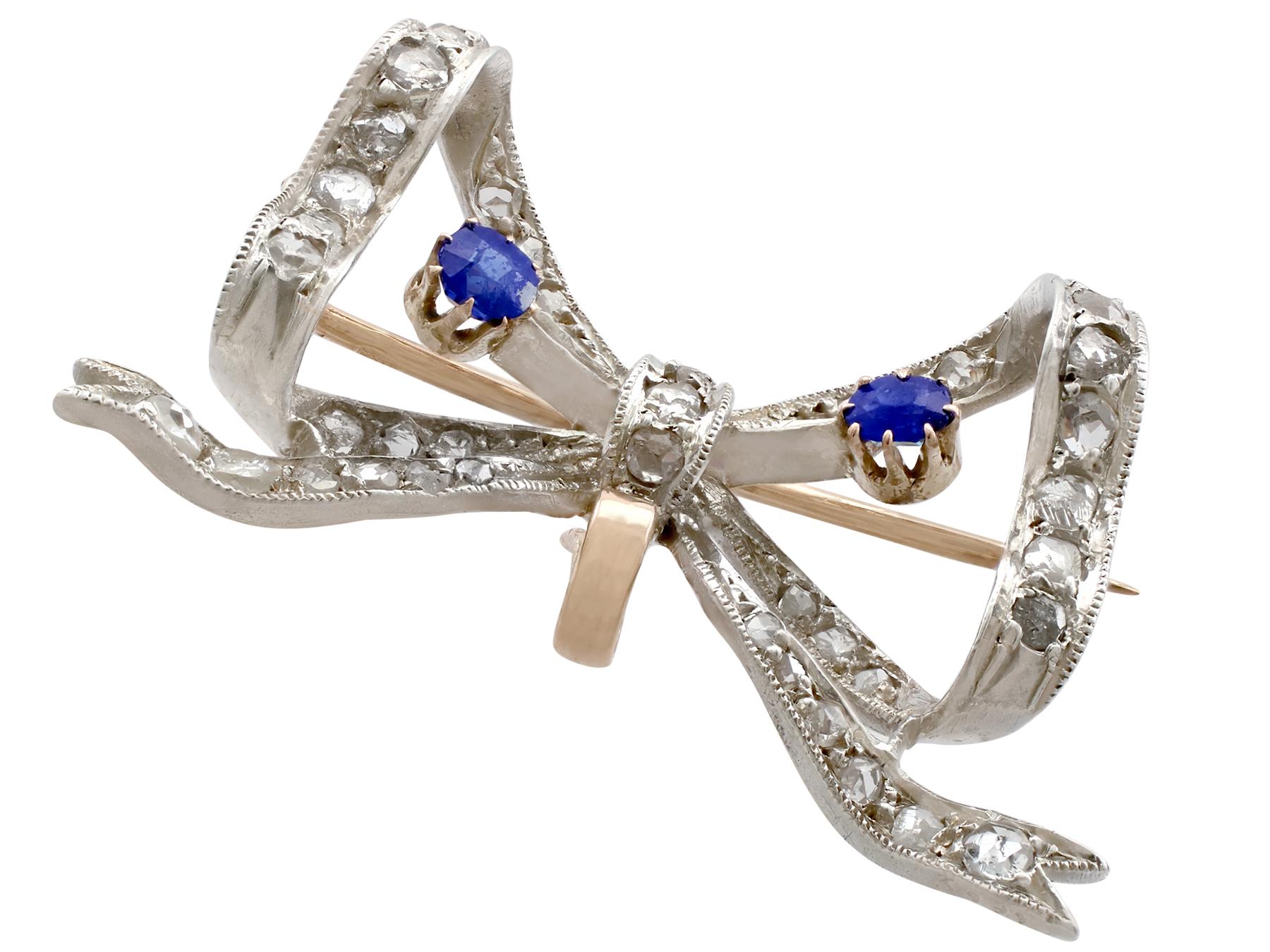 An impressive antique French 0.45 carat sapphire and 0.93 carat diamond, 15 karat yellow gold and silver set brooch; part of our diverse antique jewelry and estate jewelry collections.

This fine and impressive antique bow brooch has been crafted in