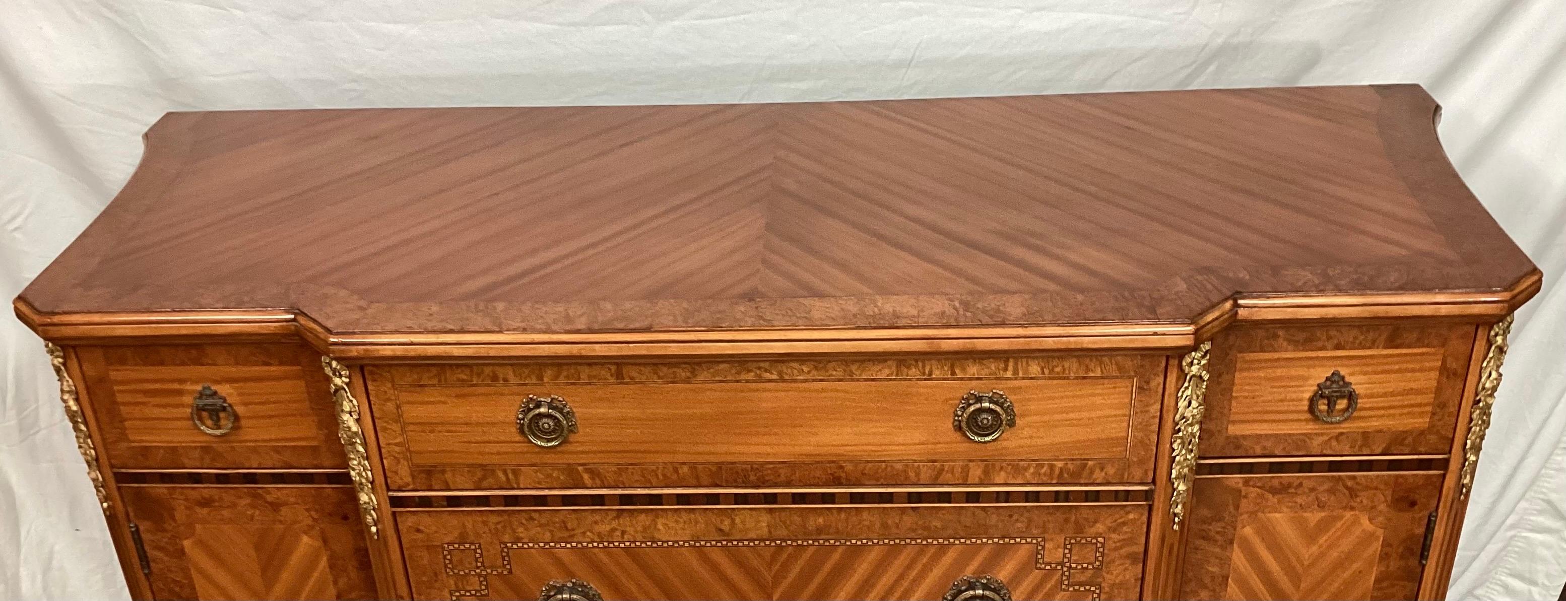 Antique French satinwood dresser or sideboard with Bronze Mounts. This piece has been used as a dresser for years. Book matched statin wood veneer with bronze mounts on the corners and hardware. Inlaid trim and carved feet. 55 1/4