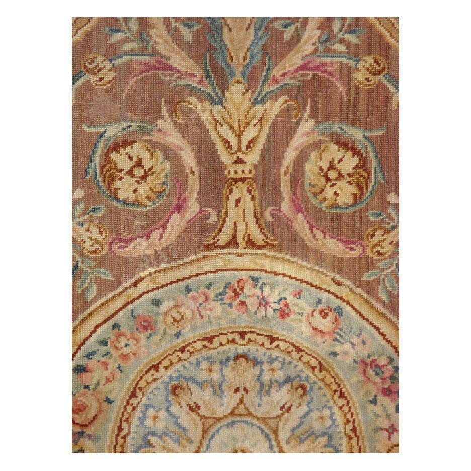 An antique French Savonnerie rug handmade during the early 20th century in the Louis XV style.