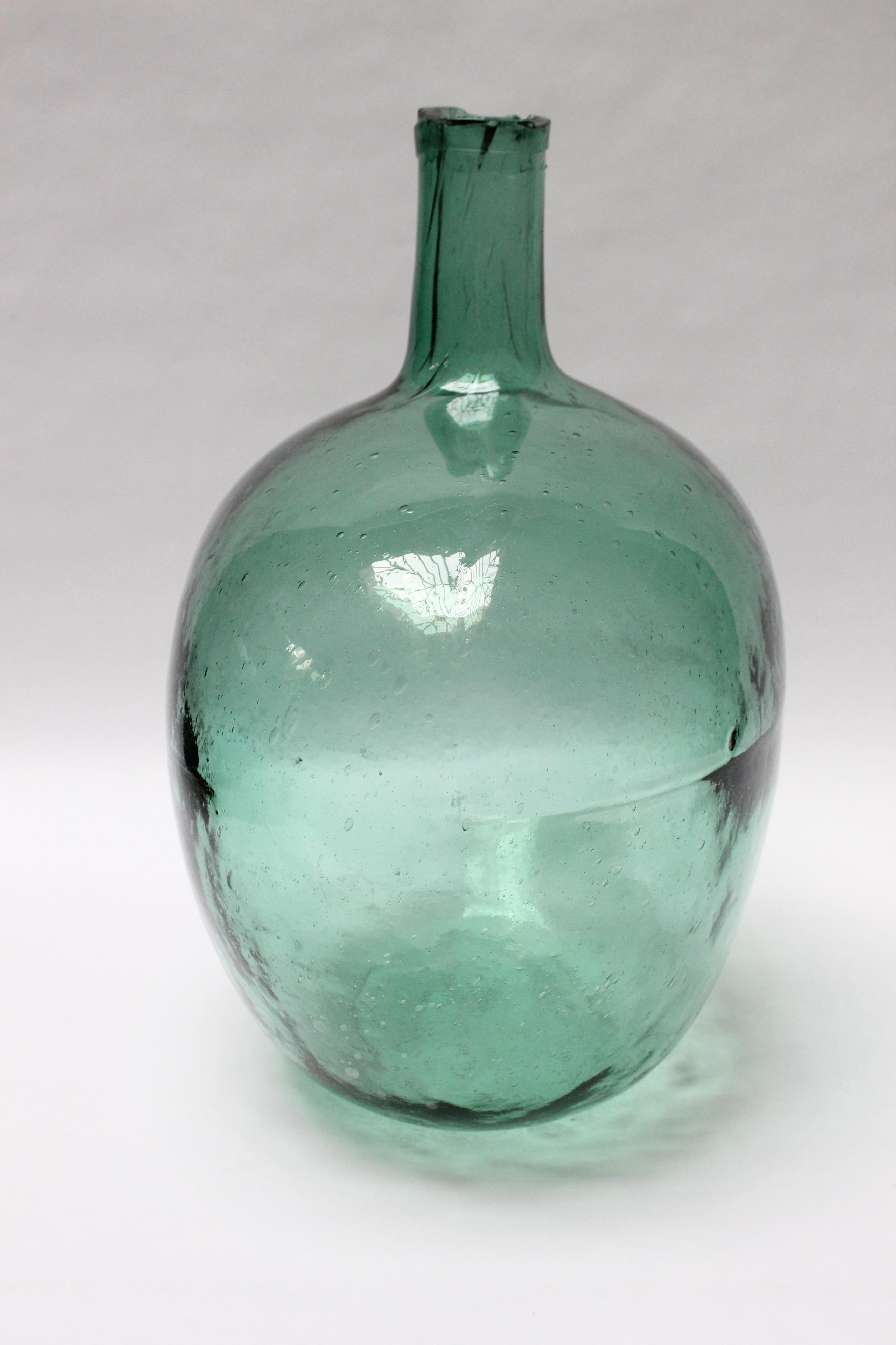 French Demijohn / Carboy originally used for transporting wine (ca. late 19th Century, France). Composed of free-blown seafoam glass exhibiting trapped air bubbles within the glass itself with a sheared lip. Striking color and unique form, measuring