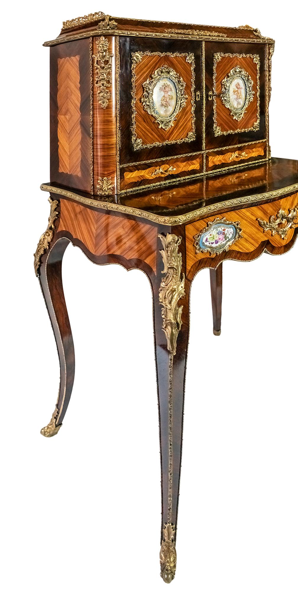 French antique secretaire in rosewood and tulipwood verneer with polished surface, decorated with bronze details outside and hand painted Sèvres Porcelain elements.
The table drawer with a sliding element inside to make a writing surface with the