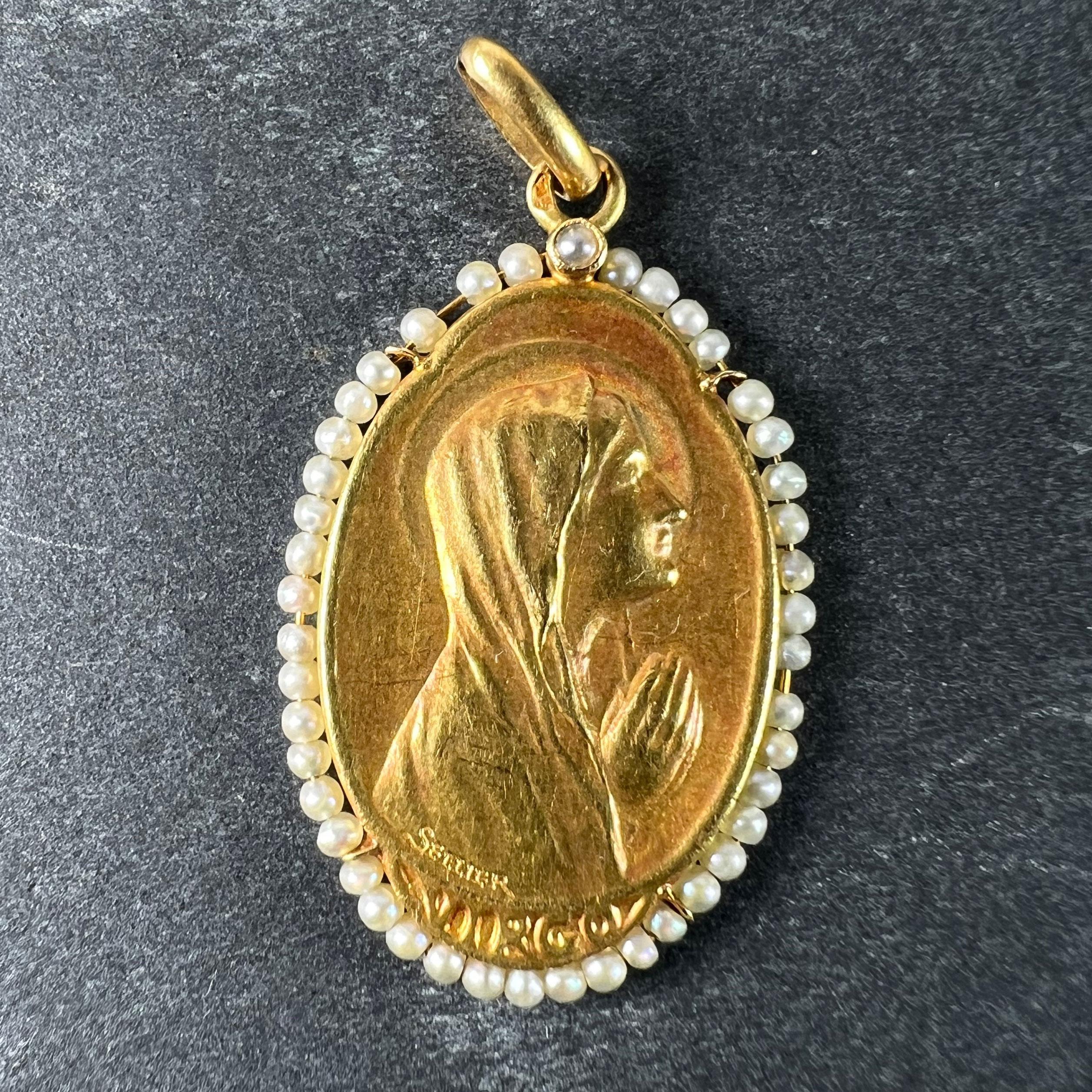 Pendentif de charme ancien en or jaune 18 carats (18K) conçu comme une médaille représentant la Vierge Marie priant de profil sur le mot 