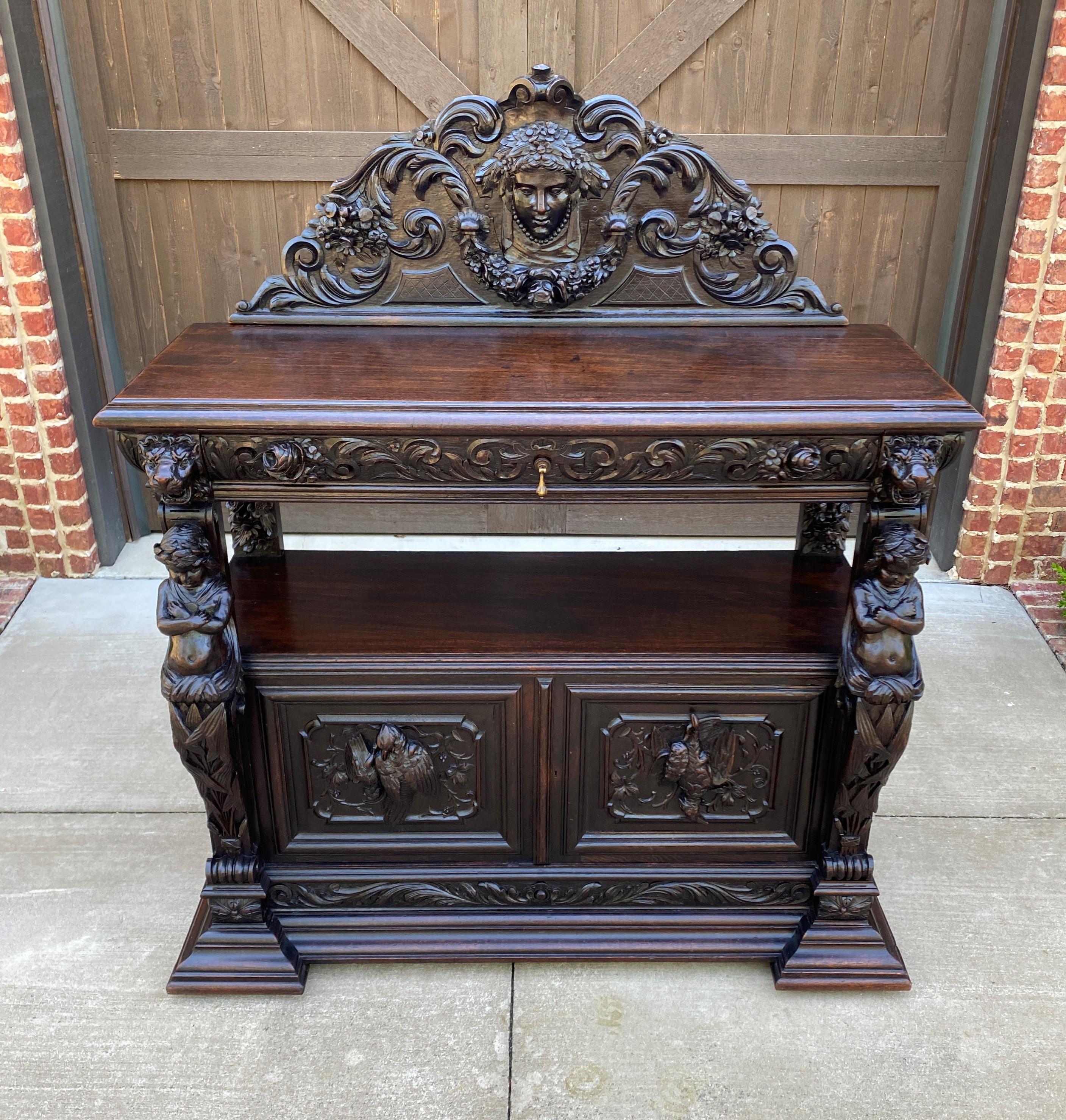 EXQUISITE Antique French GOTHIC REVIVAL Highly Carved Oak Sideboard/Server/Buffet/Cabinet~~c. 1850s

 HIGHLY CARVED antique French Gothic Revival oak sideboard, buffet, server, or cabinet with a beautifully carved mask crown, cherub supports,