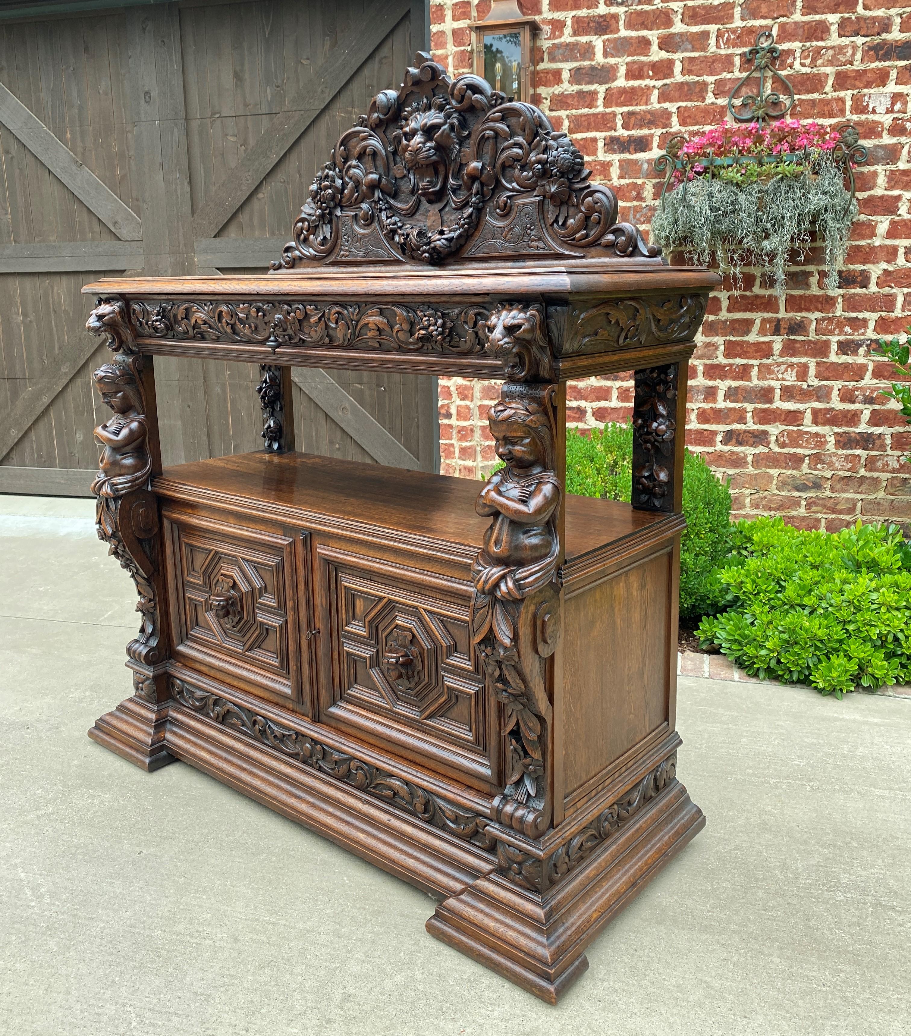 Exquisite antique french gothic revival highly carved oak sideboard/server/buffet/cabinet~~c. 1880s.

Beautiful highly carved antique French Gothic Revival oak sideboard, buffet, server, or cabinet with a beautifully carved mask crown and corner