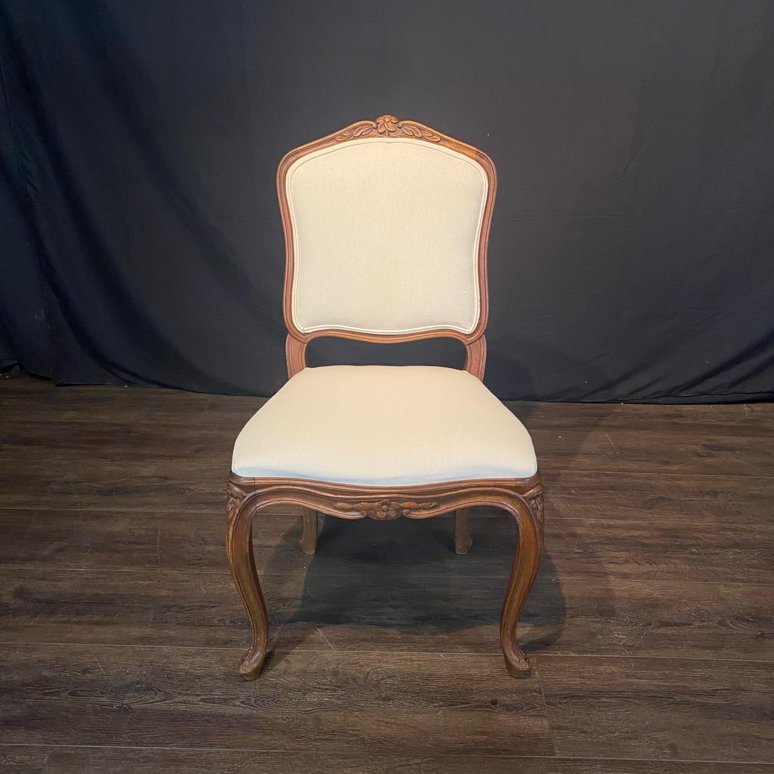 Elegant set of 6 French carved walnut dining chairs or side chairs, Louis XV 19th Century with all new upholstery. Stunning floret carvings on back, apron and legs. From Salva Freres in Paris, this one of a kind set of exquisite dining chairs has