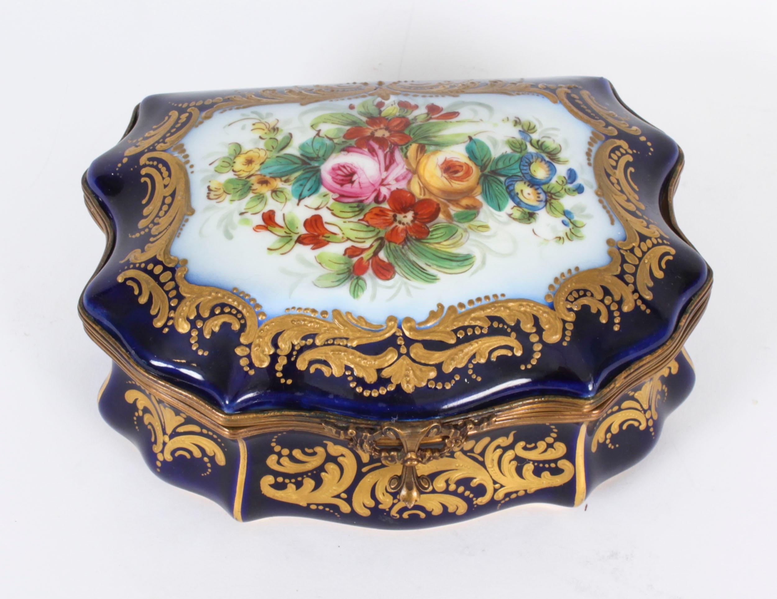 Dies ist eine fabelhafte antike Französisch Sèvres Porzellan Kobaltblau Ormolu montiert  Schatulle, ca. 1880 datiert.

Der geformte Scharnierdeckel ist mit einer handgemalten Blumengirlande in einer reich vergoldeten Bordüre verziert, die Vorder-