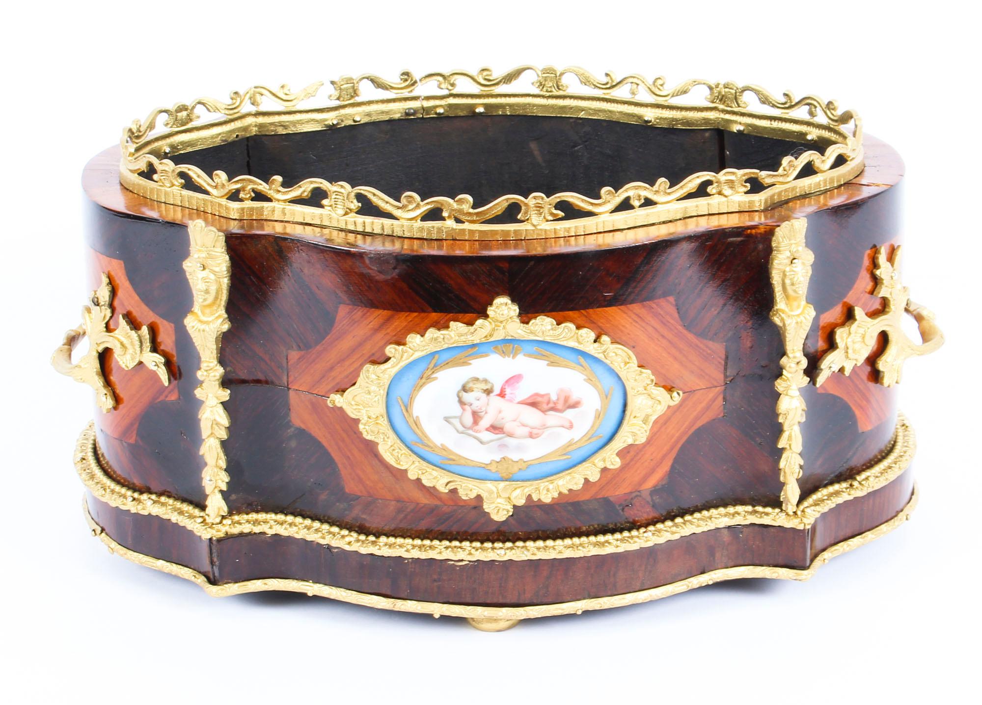 This is a beautiful antique French ormolu and Sèvres Porcelain mounted, kingwood jardiniere, circa 1860 in date.

The jardinière is serpentine in shape with ormolu mounts enclosing an enchanting hand painted and gilded Sèvres Porcelain plaque with