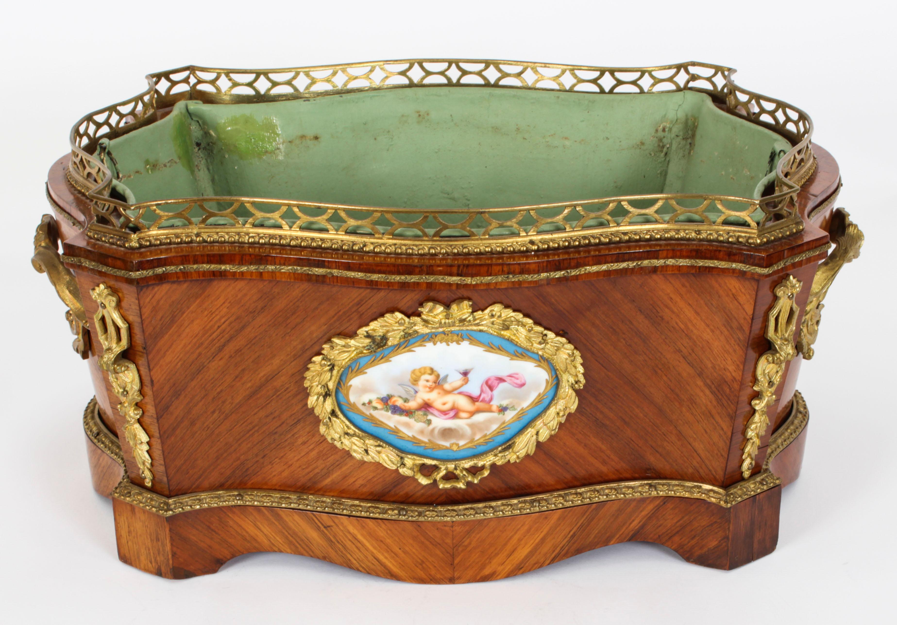 This is a beautiful antique French ormolu and Sevres porcelain mounted wood jardiniere, circa 1860 in date.
 
The jardiniere is serpentine in shape with ormolu mounts enclosing an enchanting hand painted and gilded Sevres porcelain plaque with