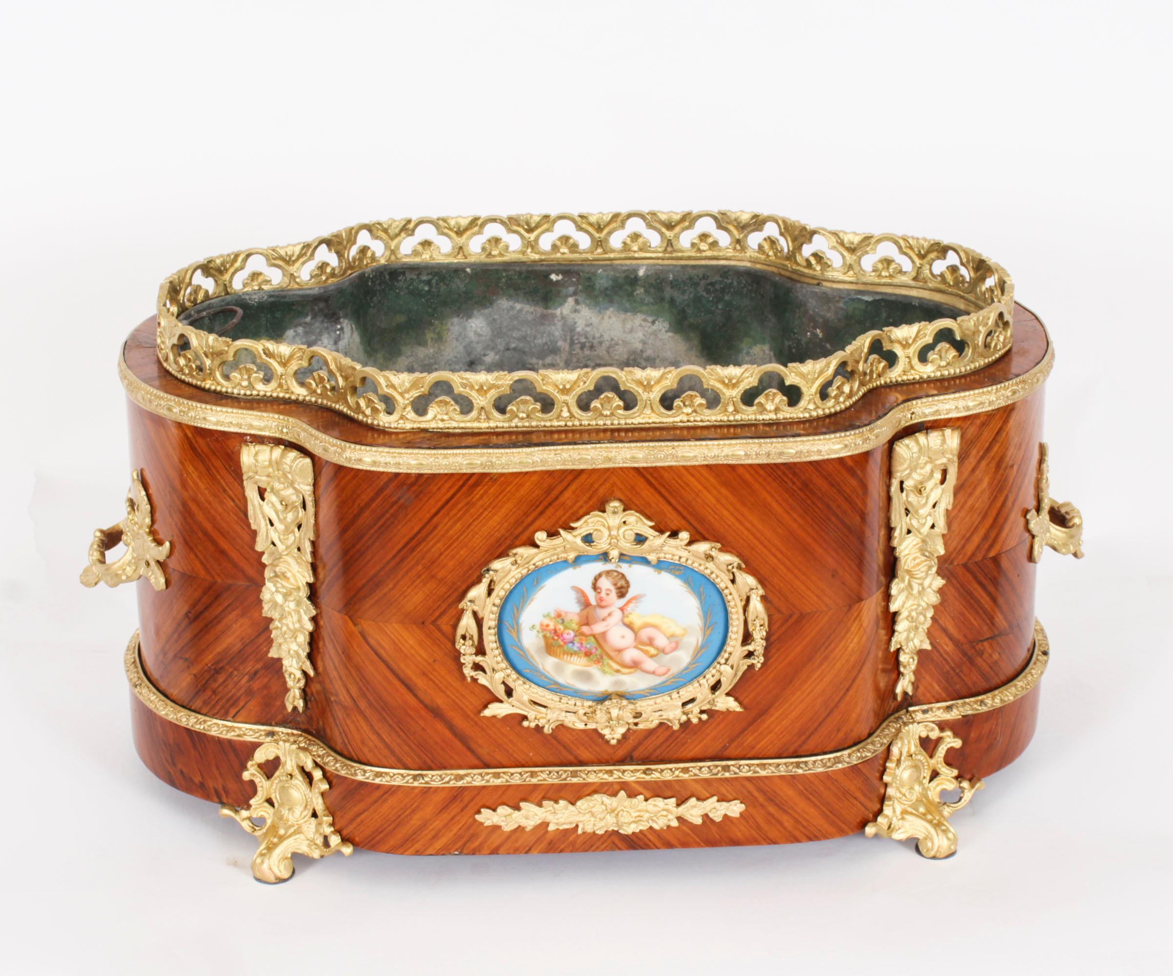 This is a superb antique French Louis XV revival ormolu and Sevres porcelain mounted, wood jardiniere, circa 1860 in date.
 
This beautiful shaped planter has splendid ormolu mounts enclosing two enchanting hand-painted and gilded Sevres porcelain
