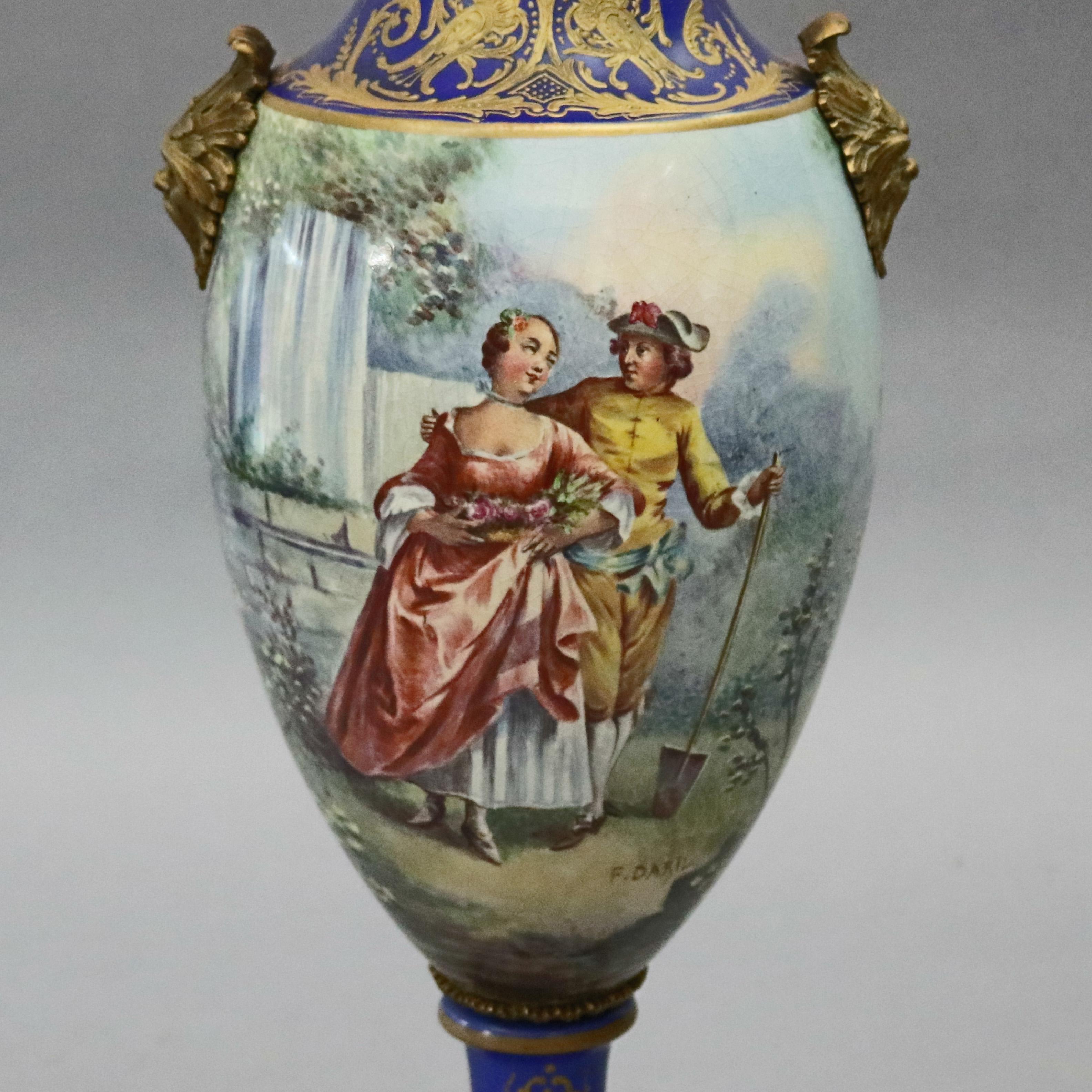 An antique French Sevres School pictorial urn offers hand painted porcelain with courting scene signed F. Daryl and gilt scroll and foliate decoration throughout, figural bronze double handles and seated on bronze base, circa 1880

Measures -