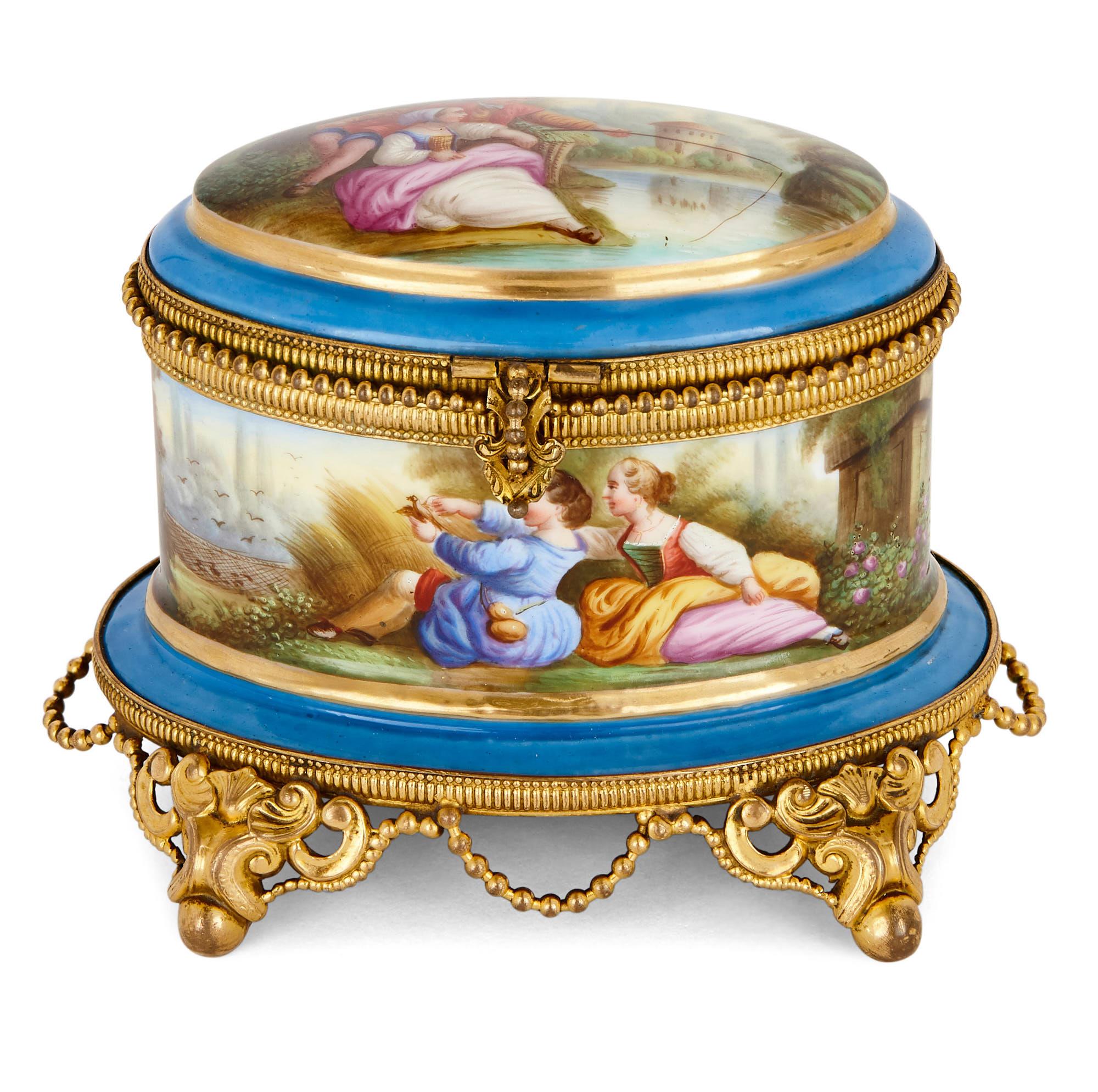 Of elliptical shape, this Sevres style porcelain perfume box contains fitted space for two glass perfume bottles. These bottles, which are mounted with gilt metal on their lids and around their necks, feature painted miniature scenes executed in