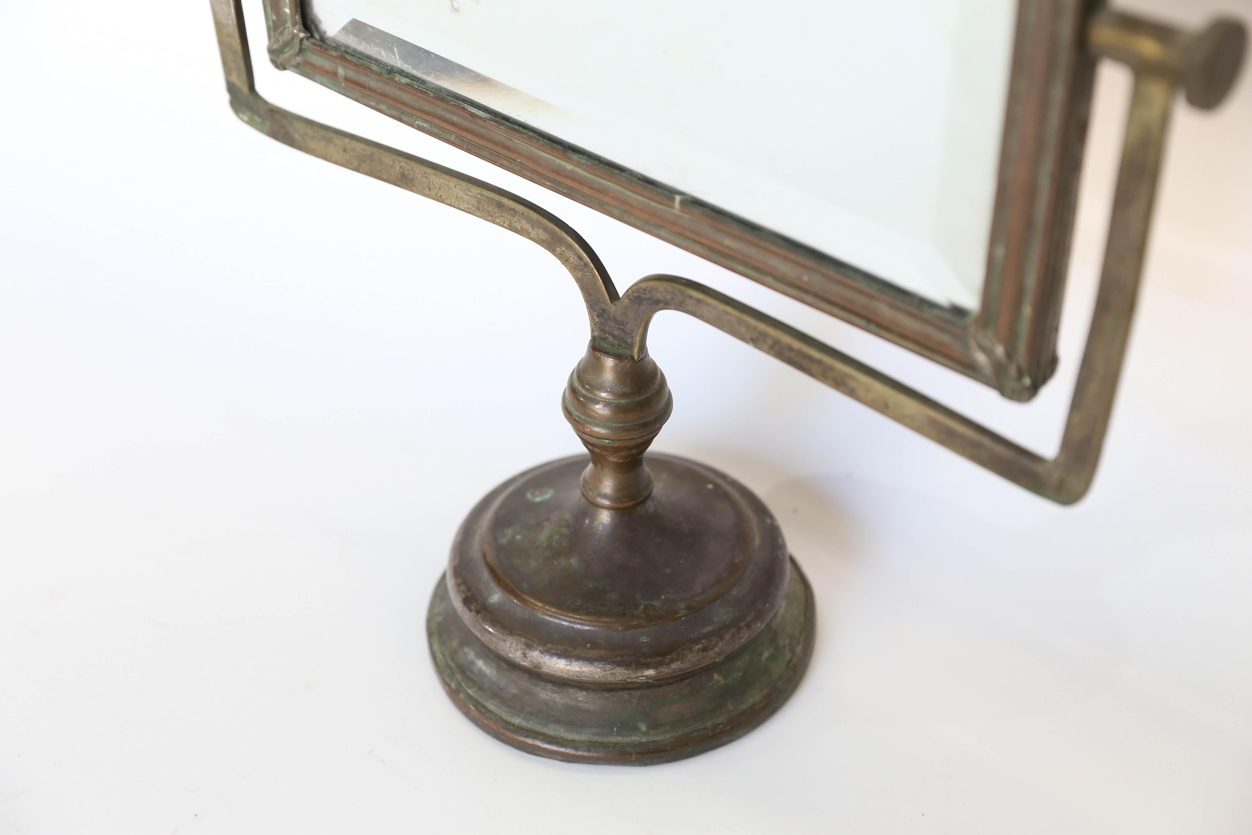 A lovely antique French shaving mirror. The beveled mirror is framed in copper and backed in wood and stands on a copper base measuring 4.5 inches in diameter. Perfect for your dressing area or a powder bath.