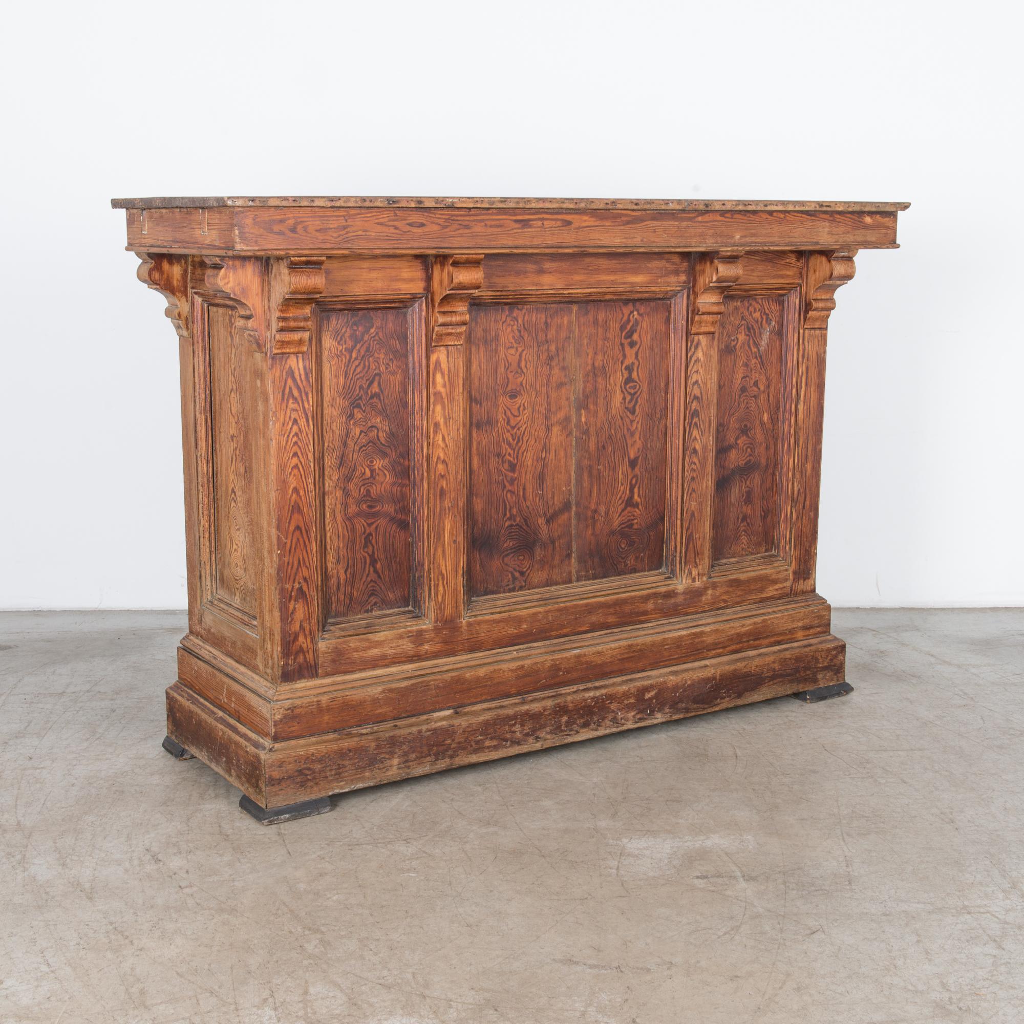 This French shop counter was constructed at the turn of the 19th century. A statement piece in all natural finish, highlighting a unique grain pattern. Rustic and refined construction from front to back, with distinguished corbels and inset