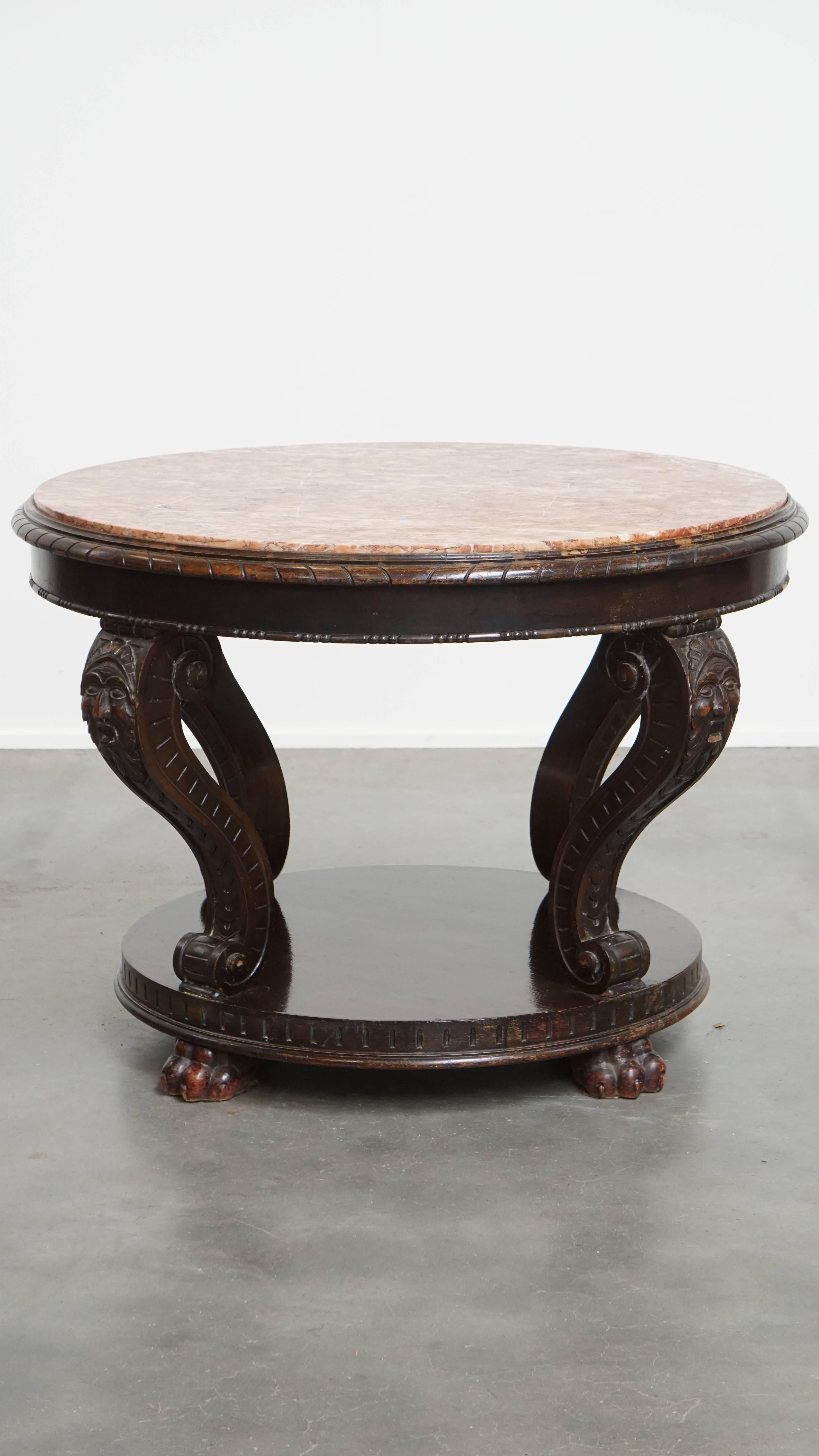 This grand antique French side table from the early 1900s with a beautifully colored marble top. This large, unique antique French side table from the early 1900s is a true eye-catcher in almost any interior. You can place it in the living room, but
