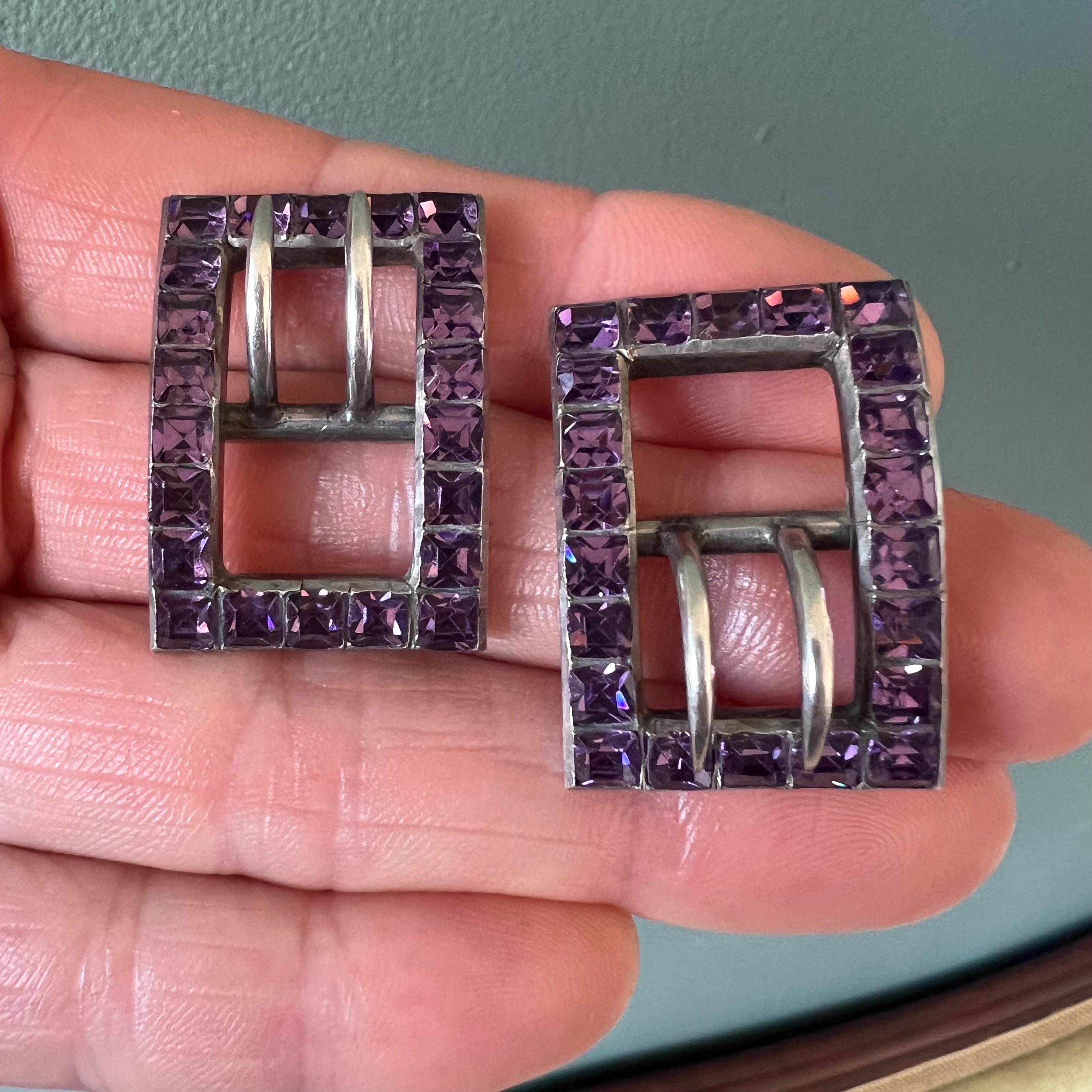 Cette paire de boucles de chaussures anciennes, serties de pierres en pâte violette de taille carrée, est un exemple étonnant d'accessoires de mode européens du XIXe siècle. Pesant 17,85 grammes et mesurant 3 cm de long sur 2,2 cm de large, ces