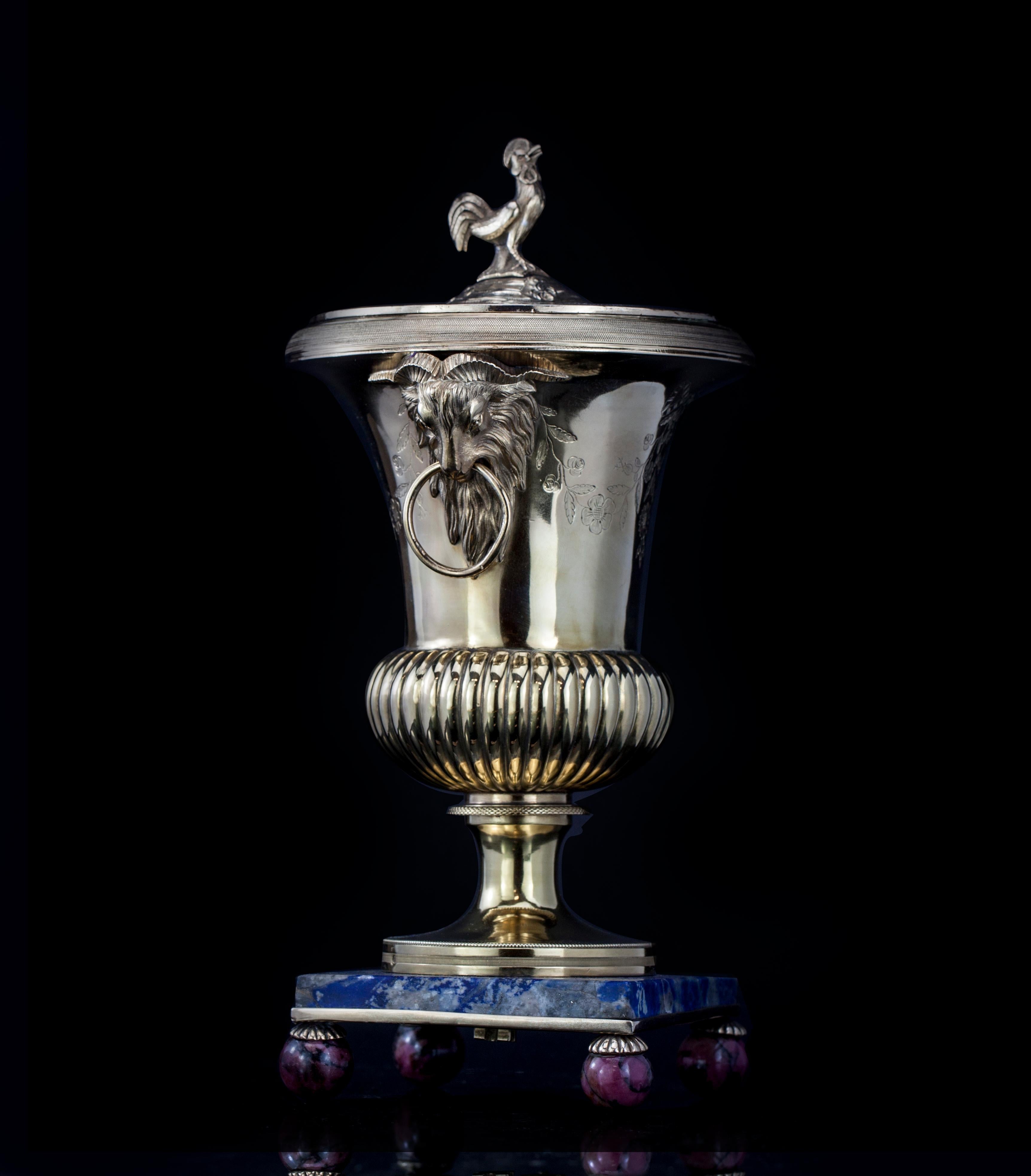 Antique French silver gilt urn with rooster lid
Mounted in Lapis Lazuli base with Rhodonite legs
Maker: N.M.R
Made in France, 1875-1915
Fully hallmarked.

Dimensions:
Approximate diameter x height 12 x 24.5 cm
Weight: 895 grams

Condition