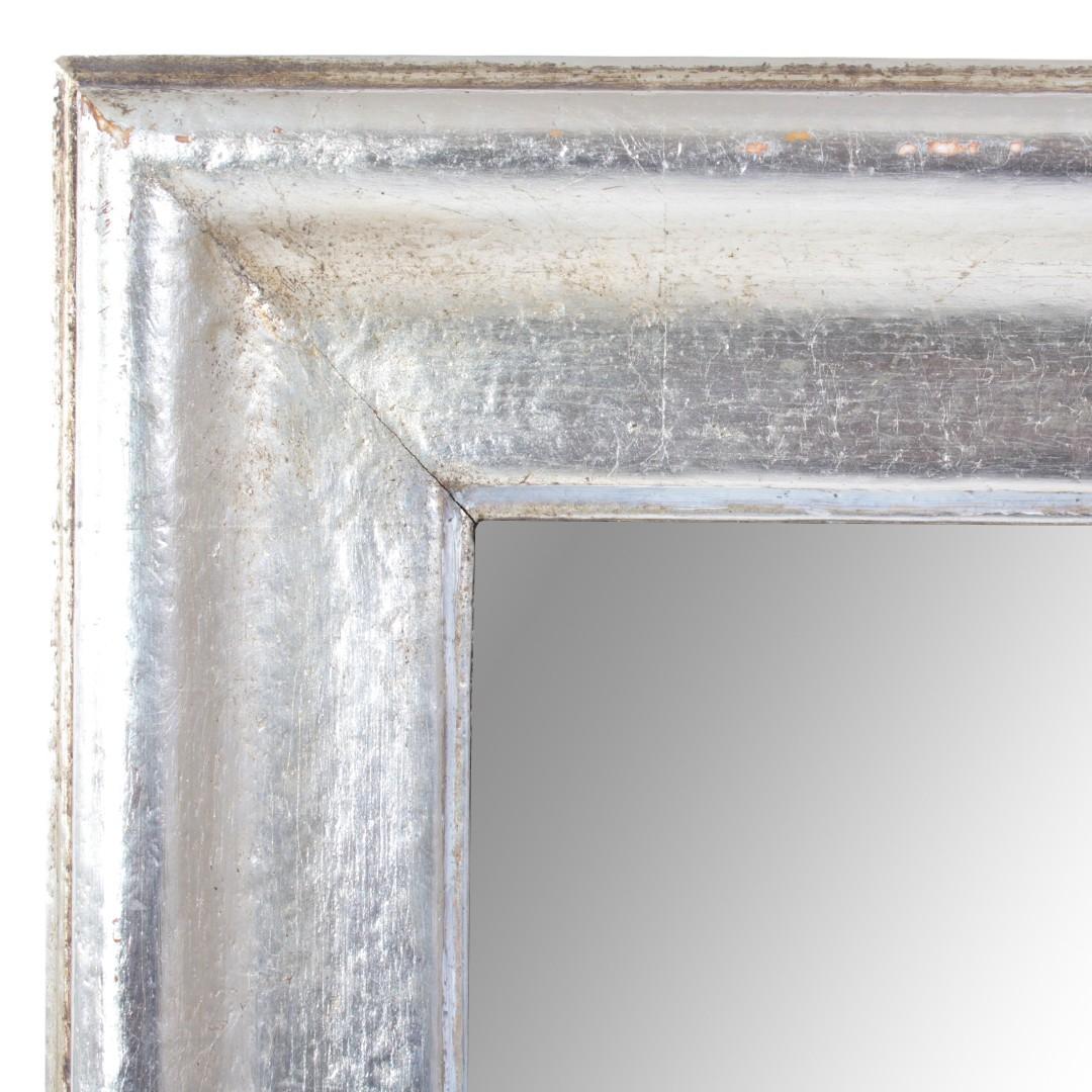 A silver giltwood wall mirror - a perfect size for placing above a bathroom sink or an entry hall console table. France, dating to the early 1900s.

Dimensions of overall frame: 28.5 inches wide x 36.5 inches tall
Dimensions of mirror area: 23